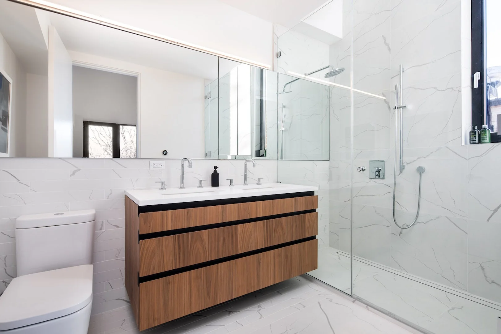 Minimalist bathroom with wood accent and marble tiling in a Brooklyn home. MEP designed by 2L Engineering.