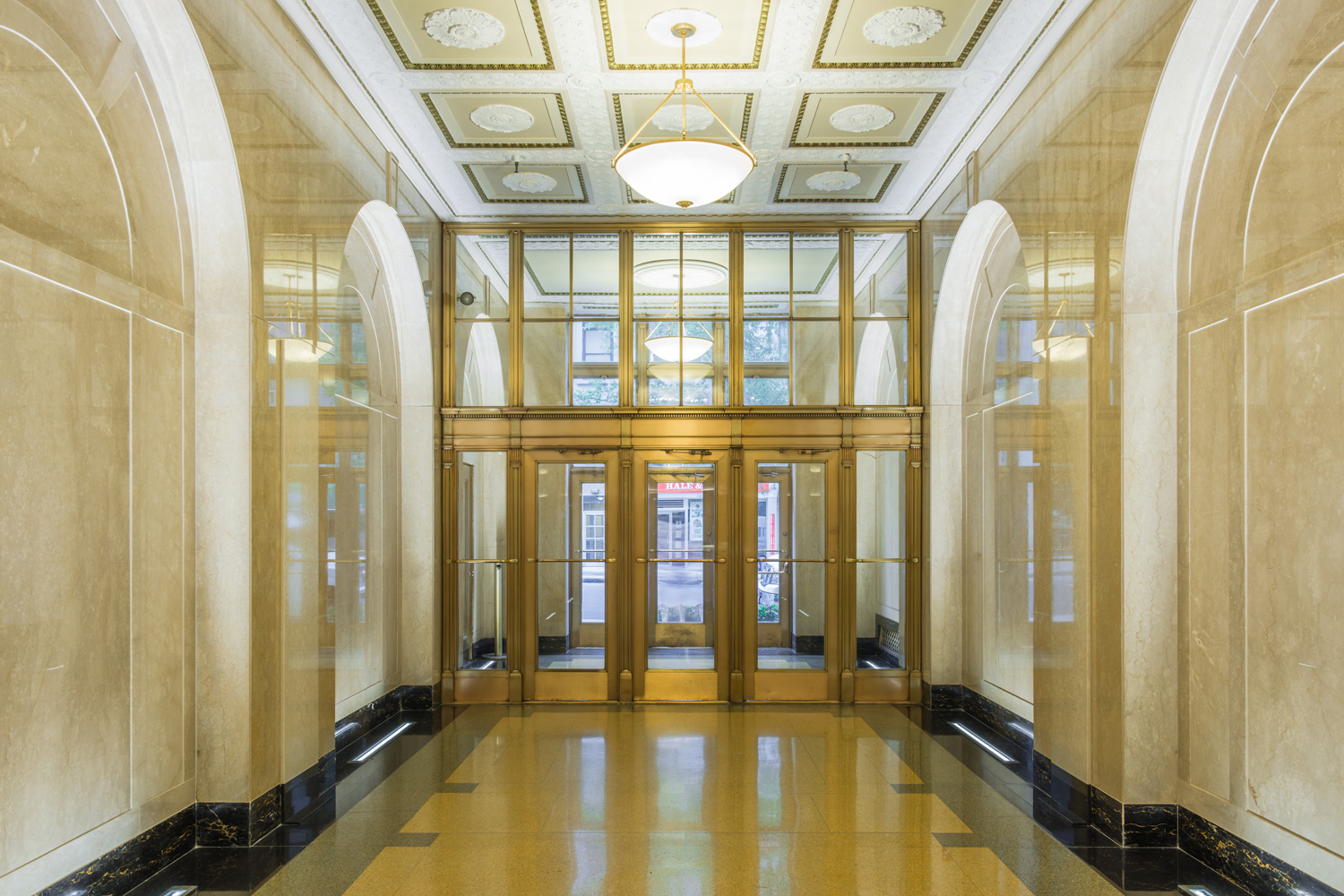 Brightly lit and gold tinted lobby of 180 Madison. MEP Engineering provided by 2L Engineering. 