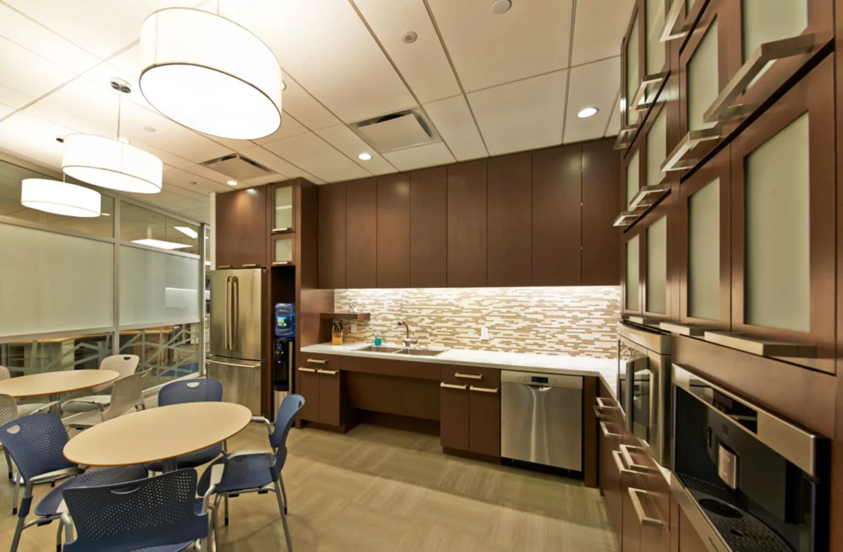 Kitchen and break room area with circular lighting and abundant storage space in the offices of Wood Mackenzie in New York. MEP designed by 2L Engineering.