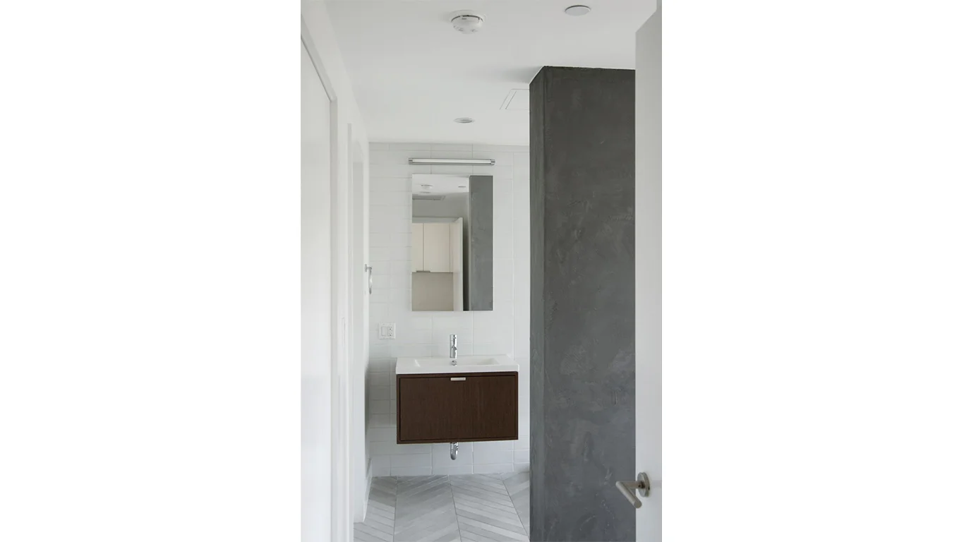 Modern, minimalistic bathroom with chevron tiles in a luxury residential home in Brooklyn. MEP designed by 2L Engineering.