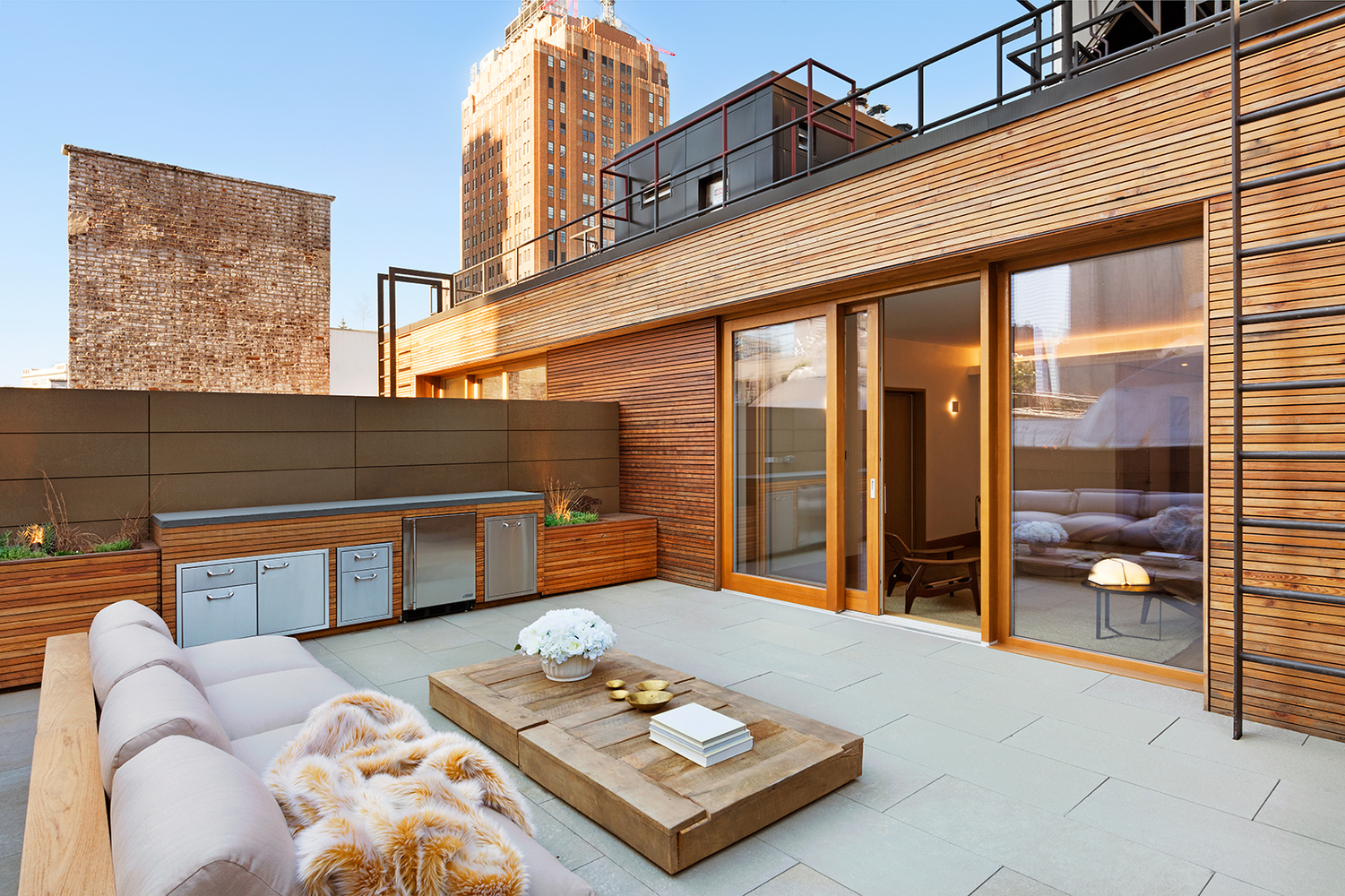 Lounge area with wood accents on the rooftop of a luxury residential building. MEP designed by 2L Engineering.