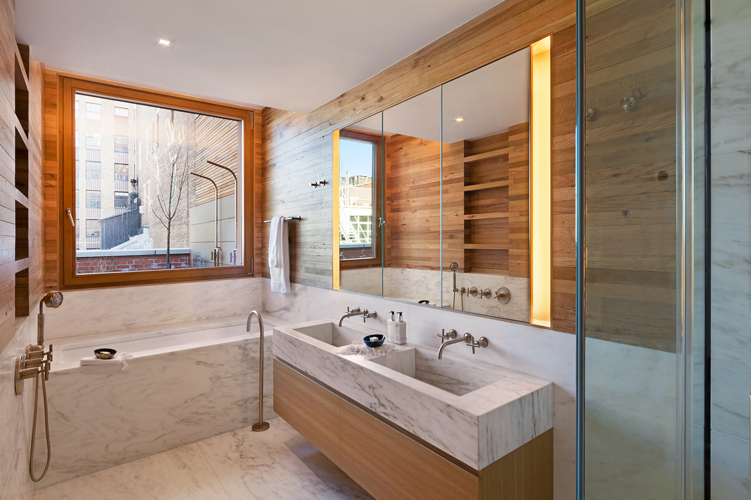 Wood paneled walls with marble accents in a luxury bathroom. MEP designed by 2L Engineering.