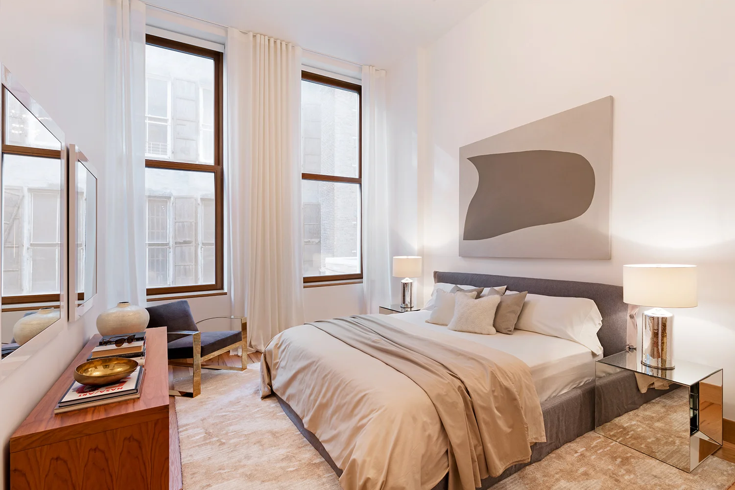 Large king sized bed in a bedroom with abstract art, contemporary modern design, and tall ceilings. MEP provided by 2L Engineering.