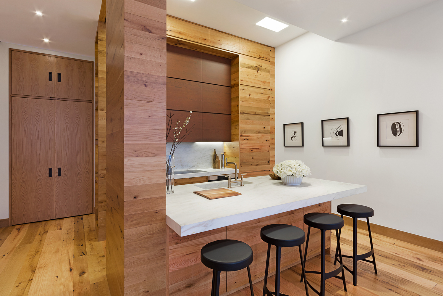 Kitchen with abundant wood accents throughout the space and abstract art on the wall. MEP provided by 2L Engineering. 