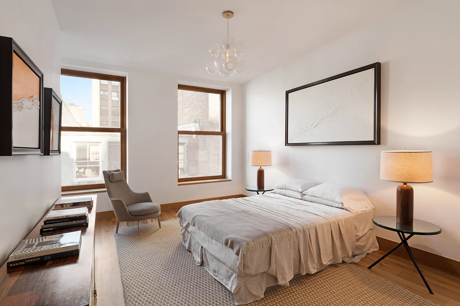 Minimalistic bedroom with white abstract artwork over the bed. MEP designed by 2L Engineering.