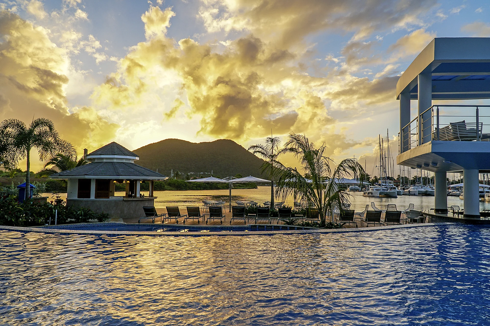 Beautiful sunset behind hills as seen from the pool at the Harbor Club Hotel in St. Lucia. MEP designed by 2L Engineering.