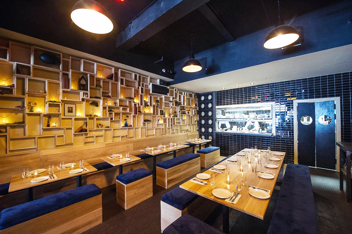 Wood shelving, tables, and chairs, mixed with blue accents on the walls, ceiling and upholstery in Pearl and Ash. MEP provided by 2L Engineering.