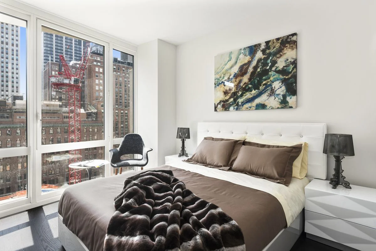Fluffy blanket on brown bed sheets in a bedroom with a marble-like painting over the headboard. MEP designed by 2L Engineering.