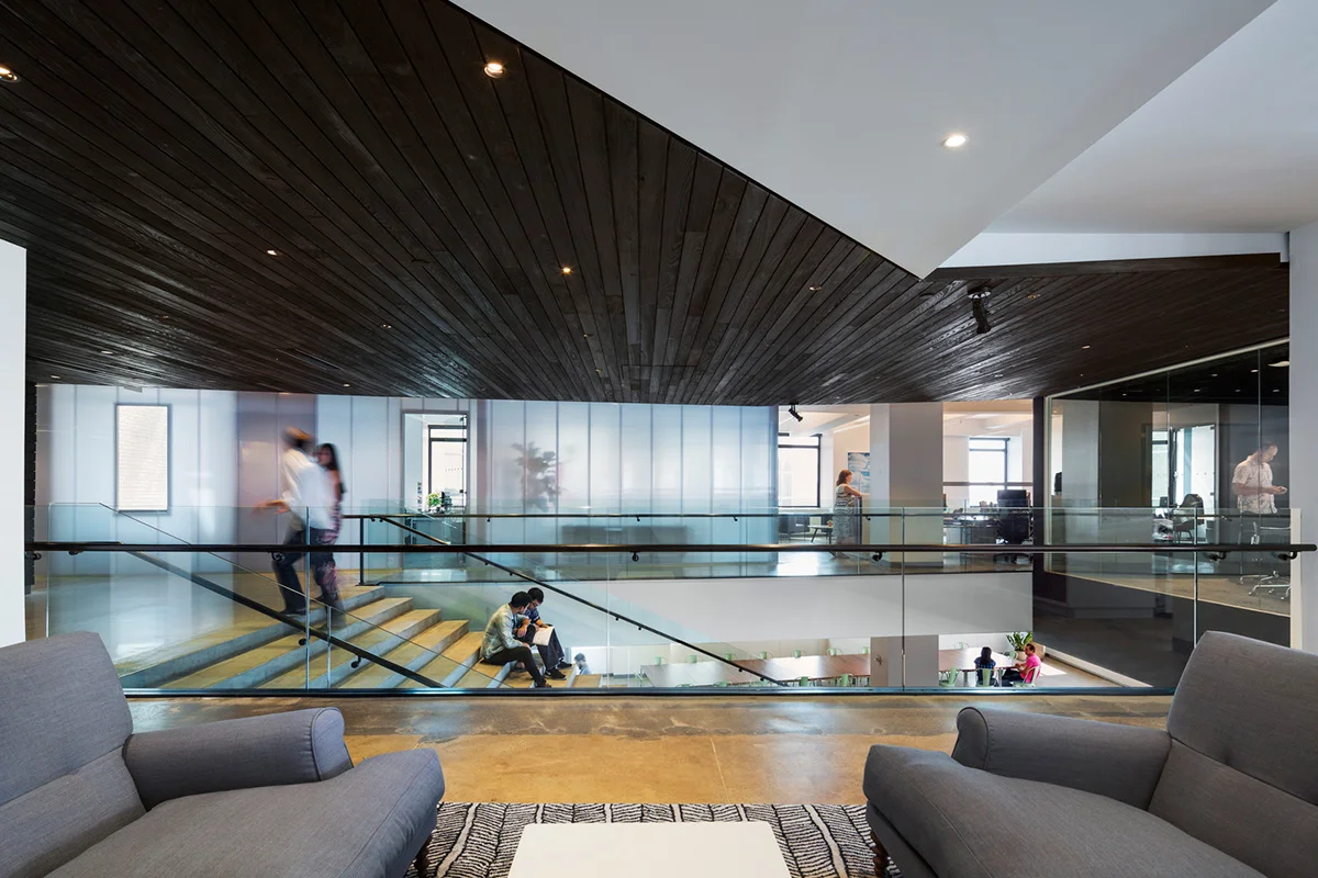 Staircase from the view of a lounge area with people interacting at the offices of Droga5, a New York based global afvertising agency. MEP provided by 2L Engineering