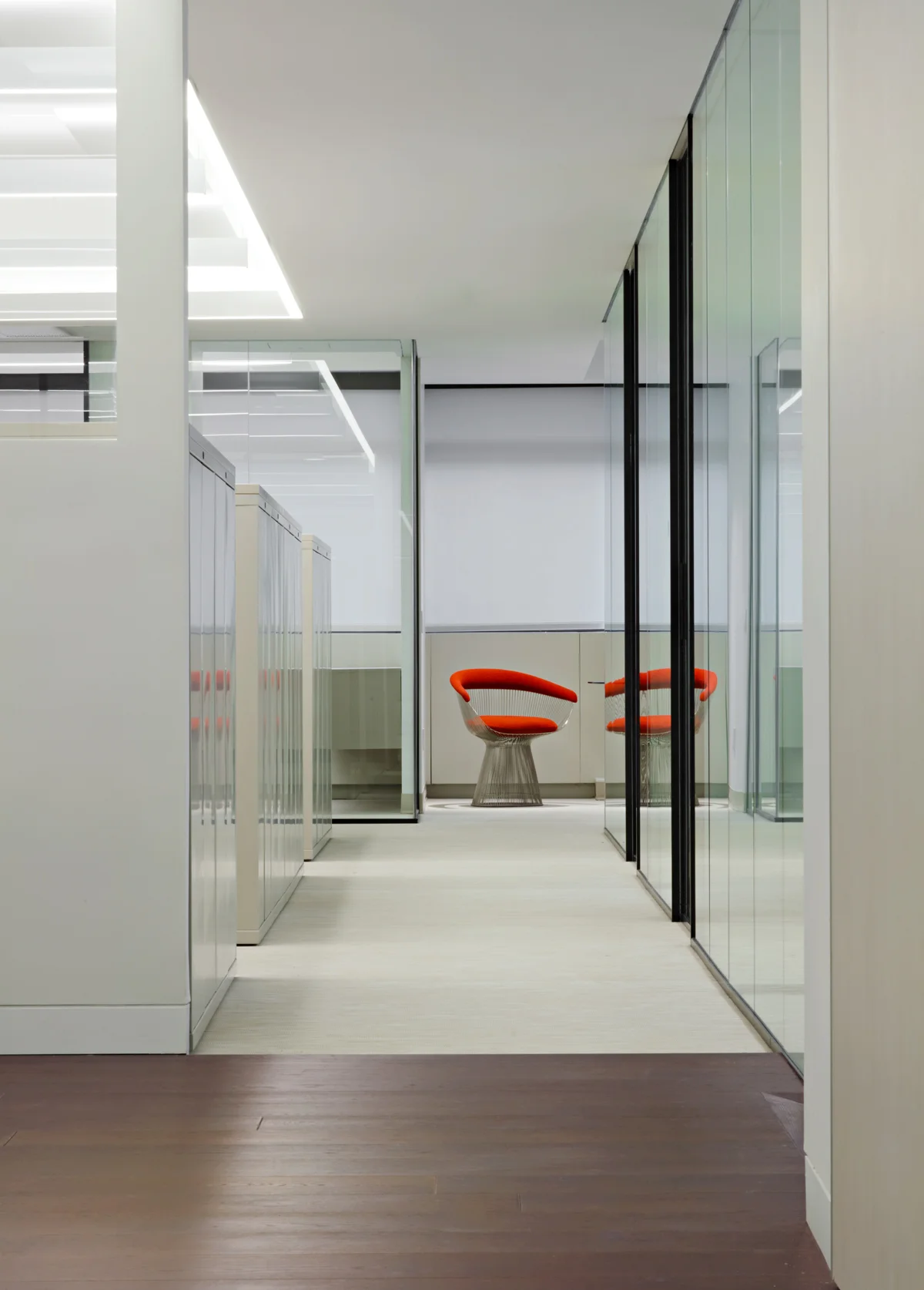 Orange cushioned chair at the end of an office hallway at Symrise, New York. MEP designed by 2L Engineering.