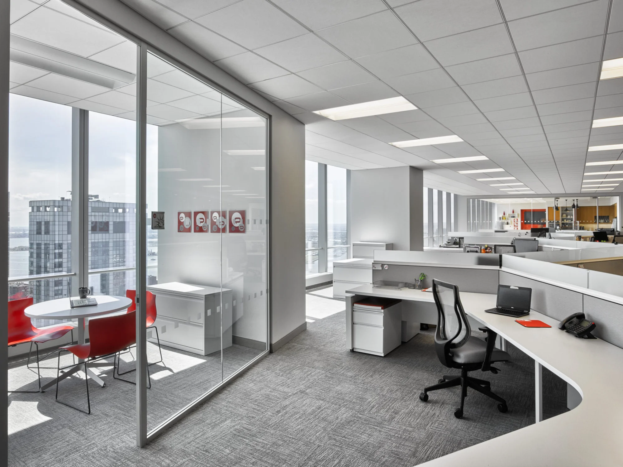 Small private meeting room beside open working spaces in the offices of Padilla CRT, a communications agency located in New York. MEP by 2L Engineering.