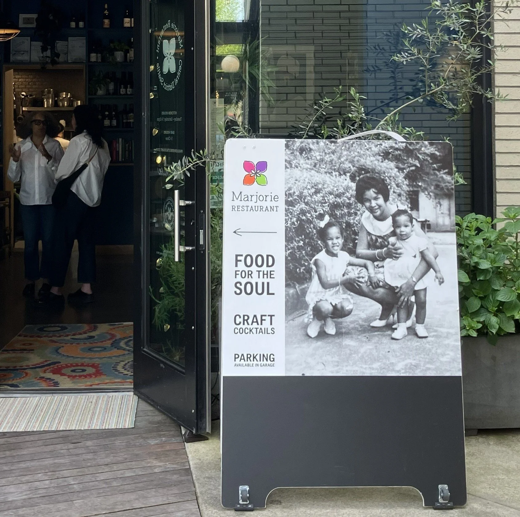 An sign outside a door with a photo of a Black woman and two young Black girls; they are embracing.