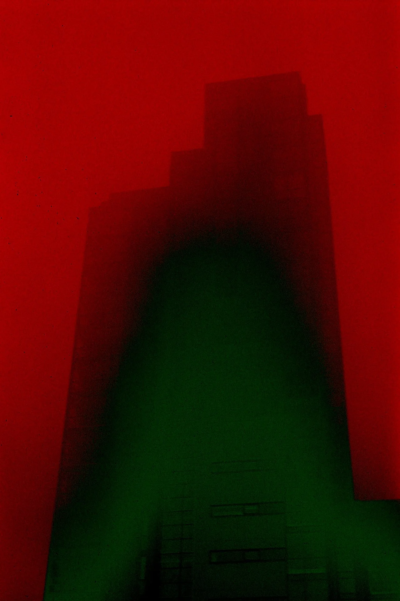 Dark skyscraper silhouette against a red and green background, with no distinguishable details.