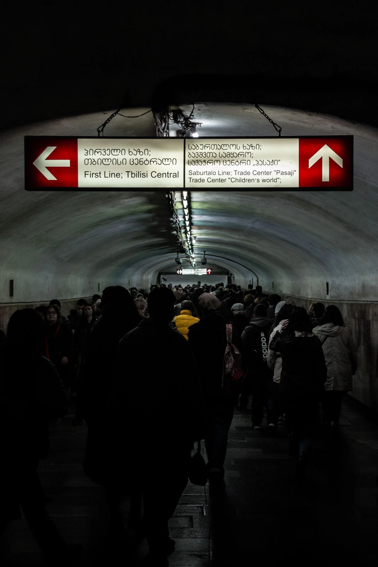 A girl with a yellow coat standing out in Tbilisi’s subway.