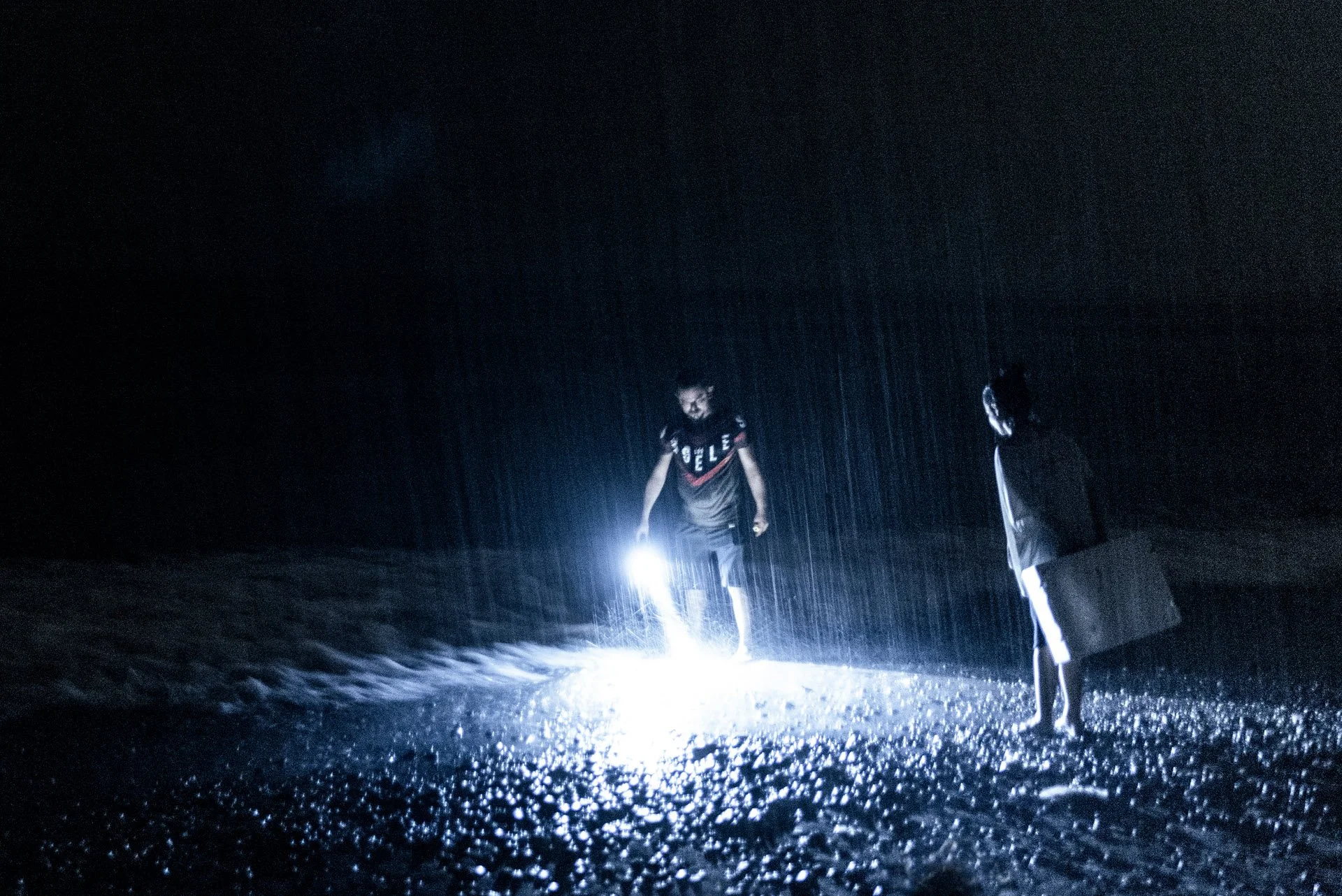  Volunteers from the organization "Third Eye Education and Youth Association of Mediterranean (T.E.A.M.)" try to locate hatchlings and help them go towards the sea using torchlights amidst a heavy thunderstorm. 