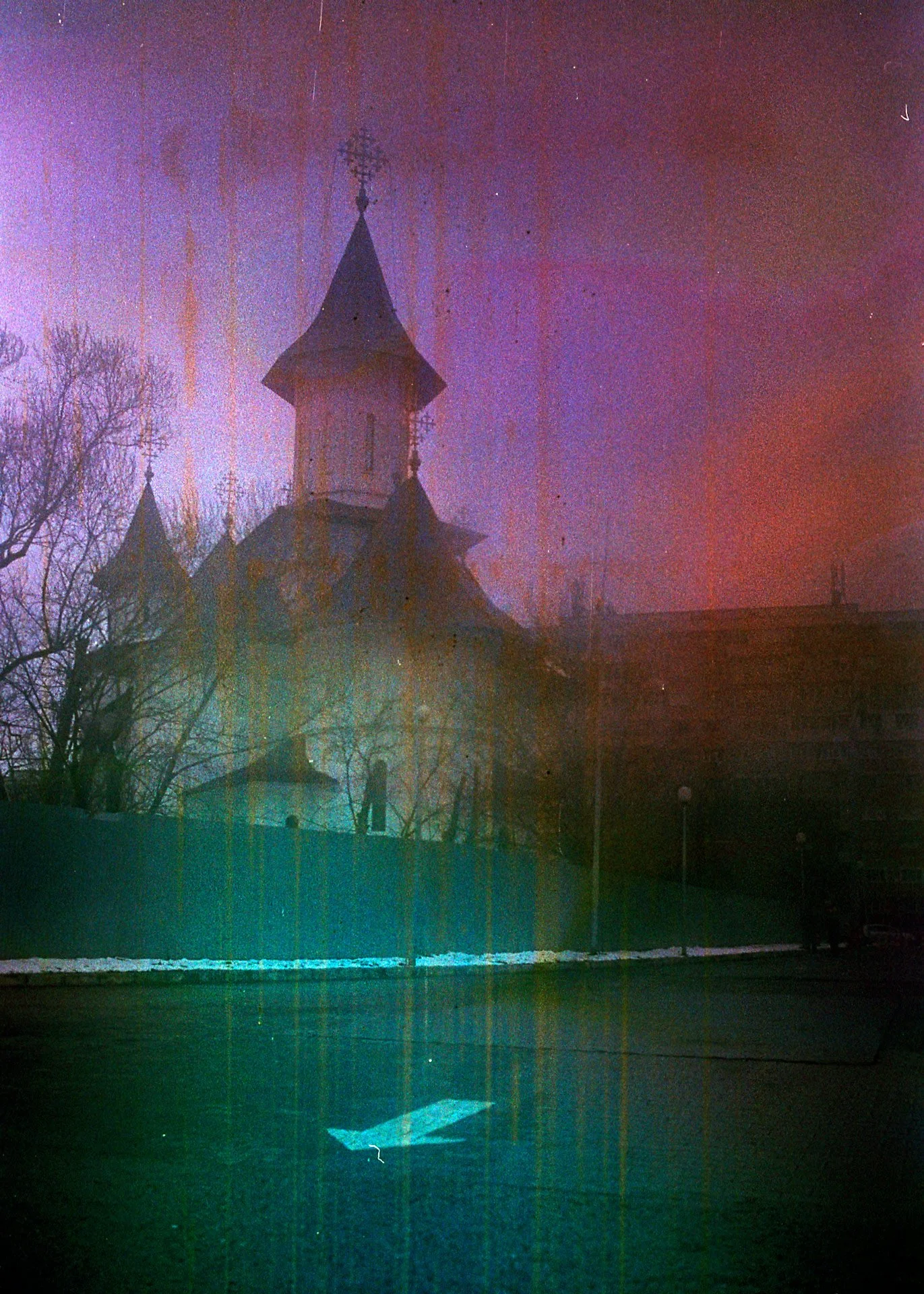 A church or historic building with towers and spires, silhouetted against a twilight sky with visible color distortions and vertical streaks.