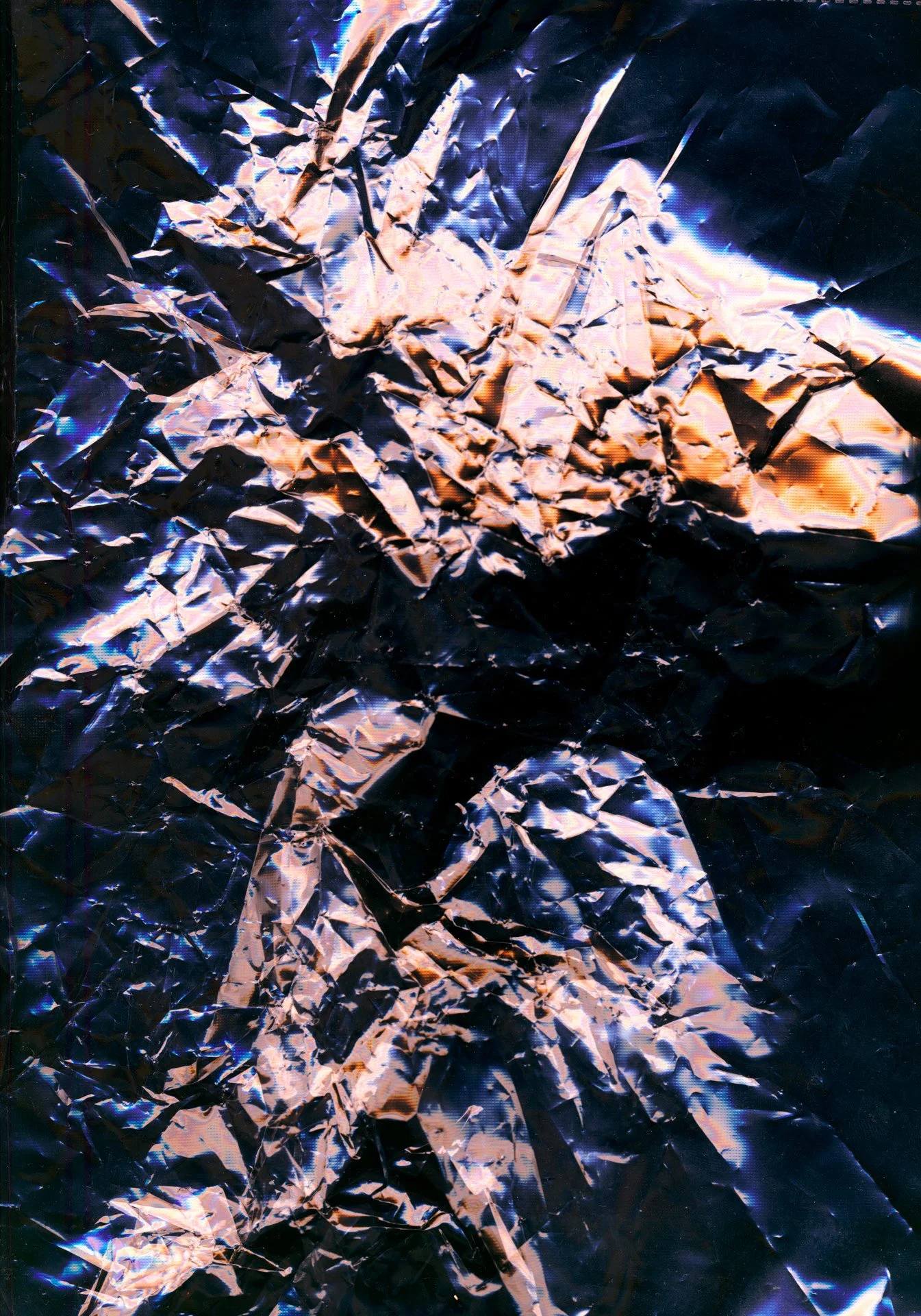 Close-up of crumpled metallic foil with reflections of blue and pink light.