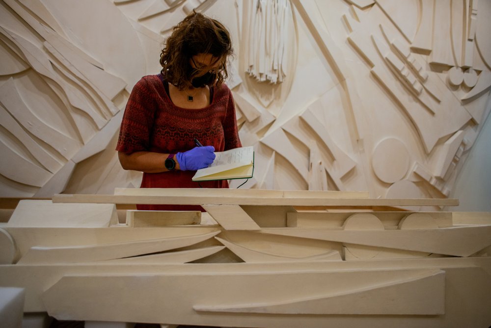  Art Conservator Martha Singer examining one of the  Trinity Columns . Photo by Andrew Seng. 