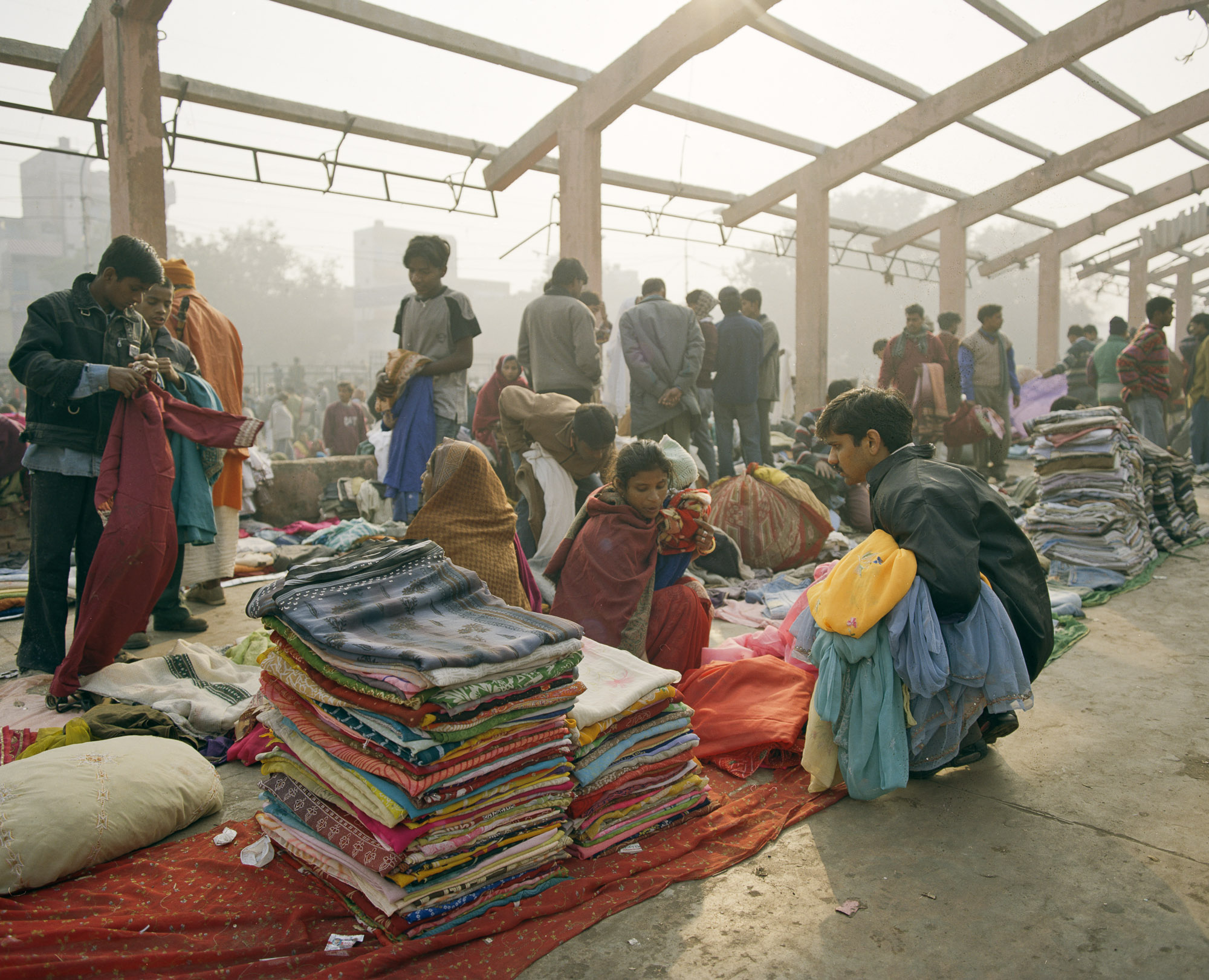 Buyers specialize in certain garments, trawling the lines of women sitting selling saris, shalwar kamiz, shirts and trousers.