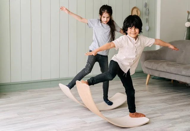 2 children balancing on rocker boards