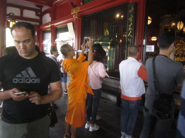 A monk photographs part of the ceremony behind the grate. Copyright 2017, Anna Broadway.