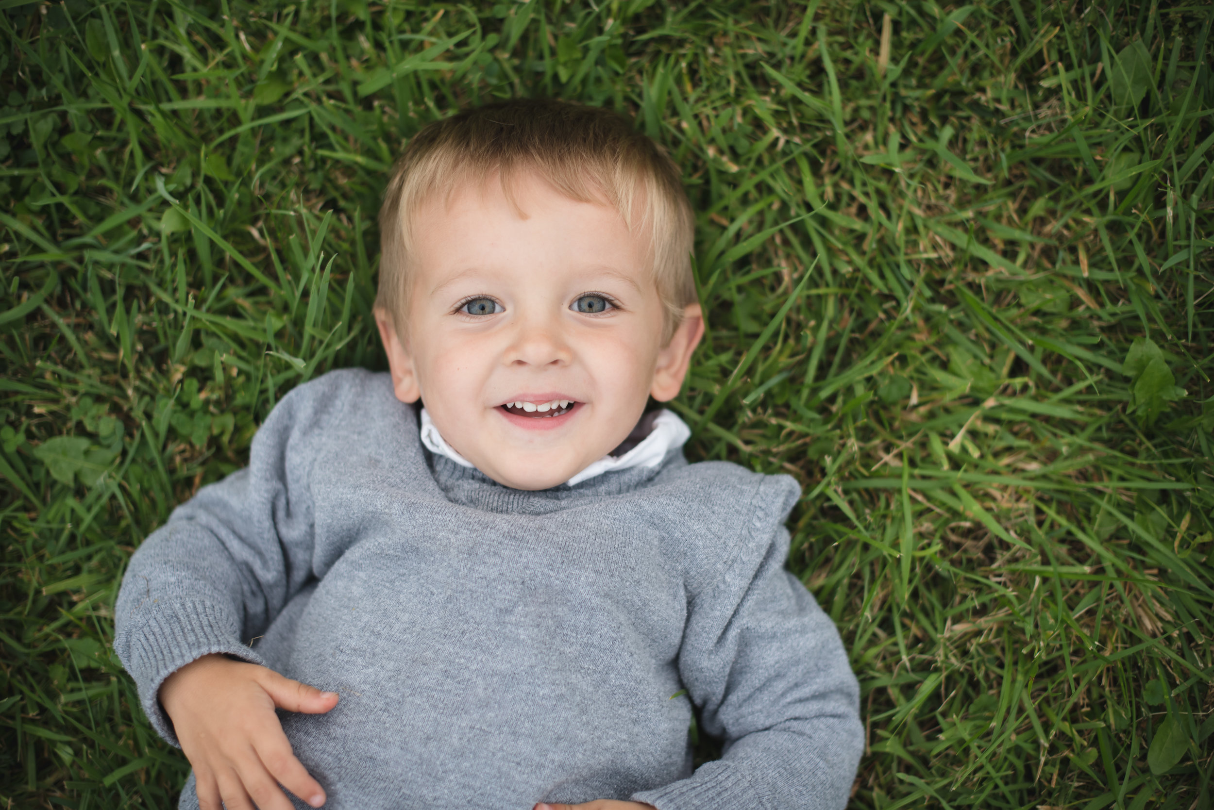 child laughing in grass