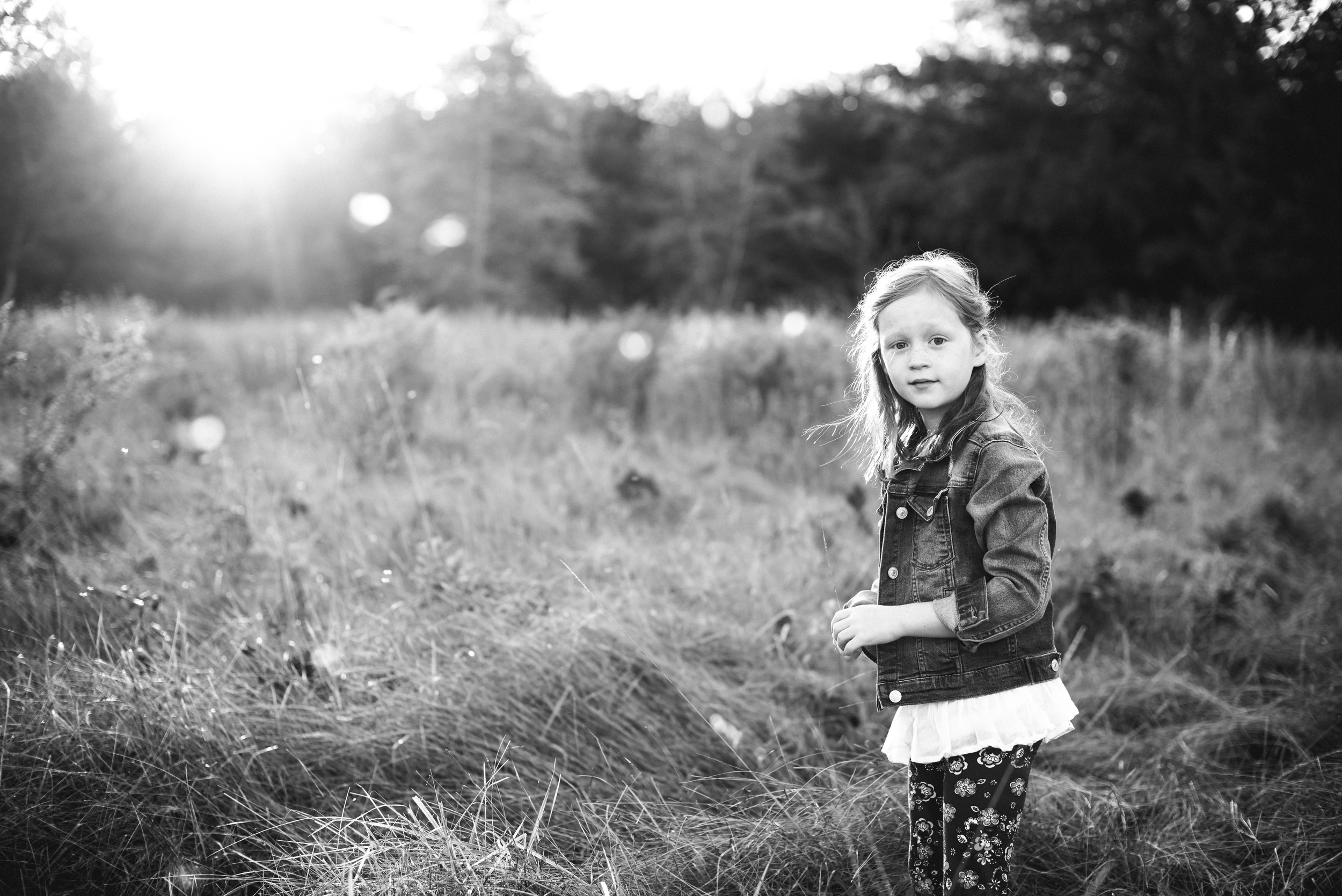 young girl in field at sunset 
