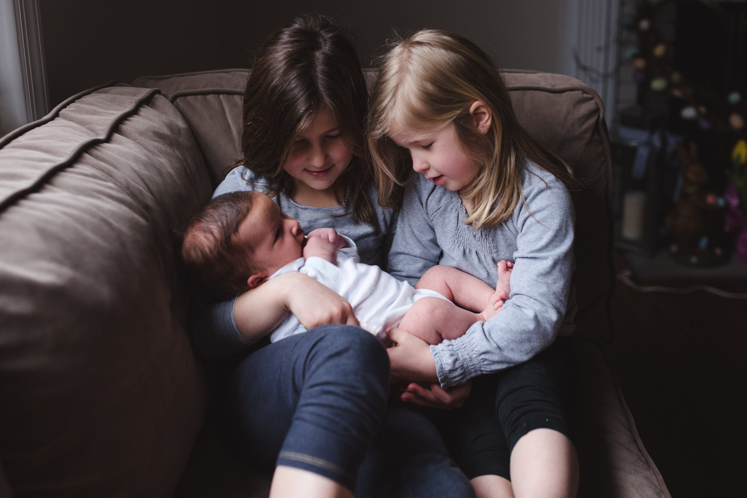 sisters holding baby brother