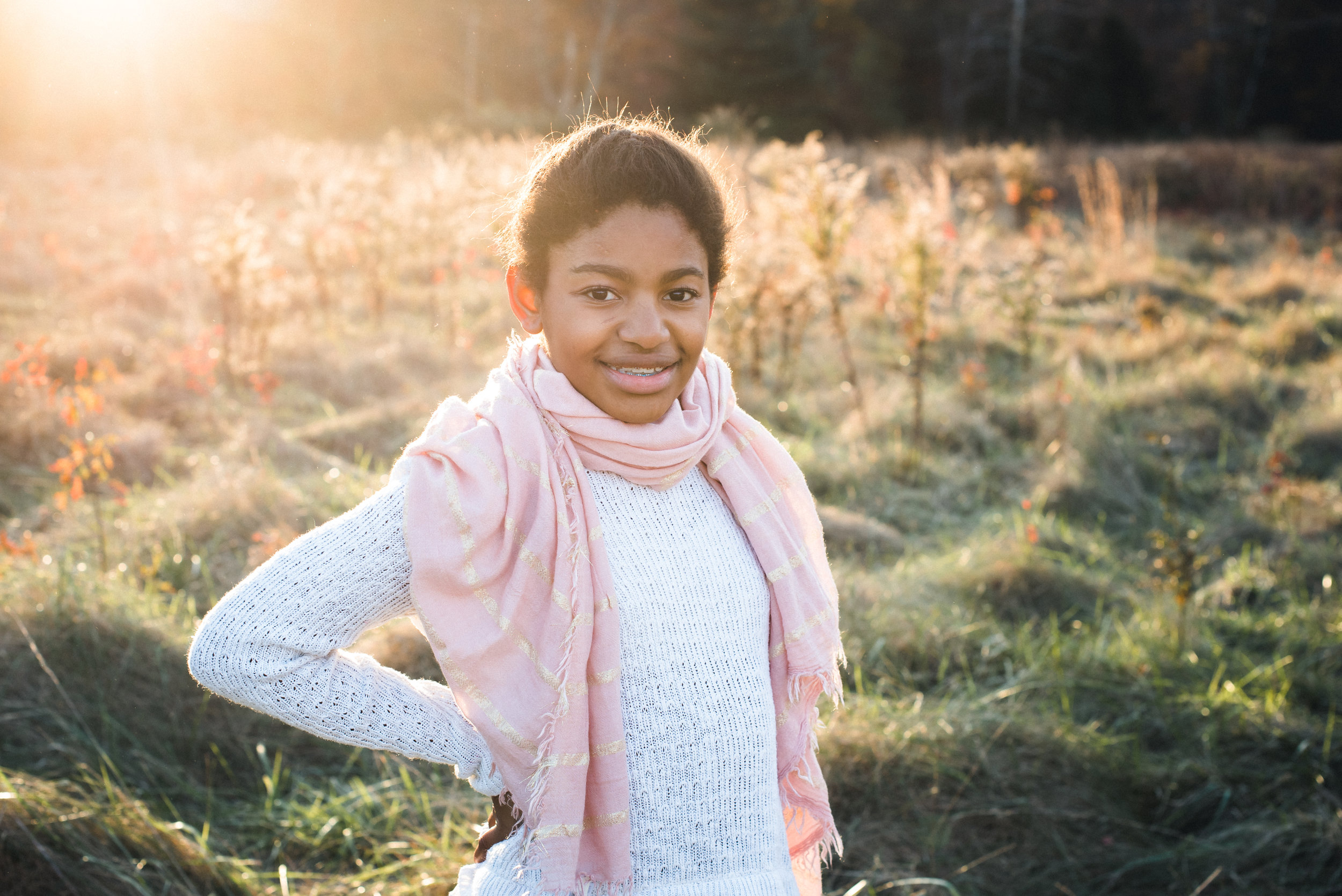 teenager with natural smile in a field at sunset
