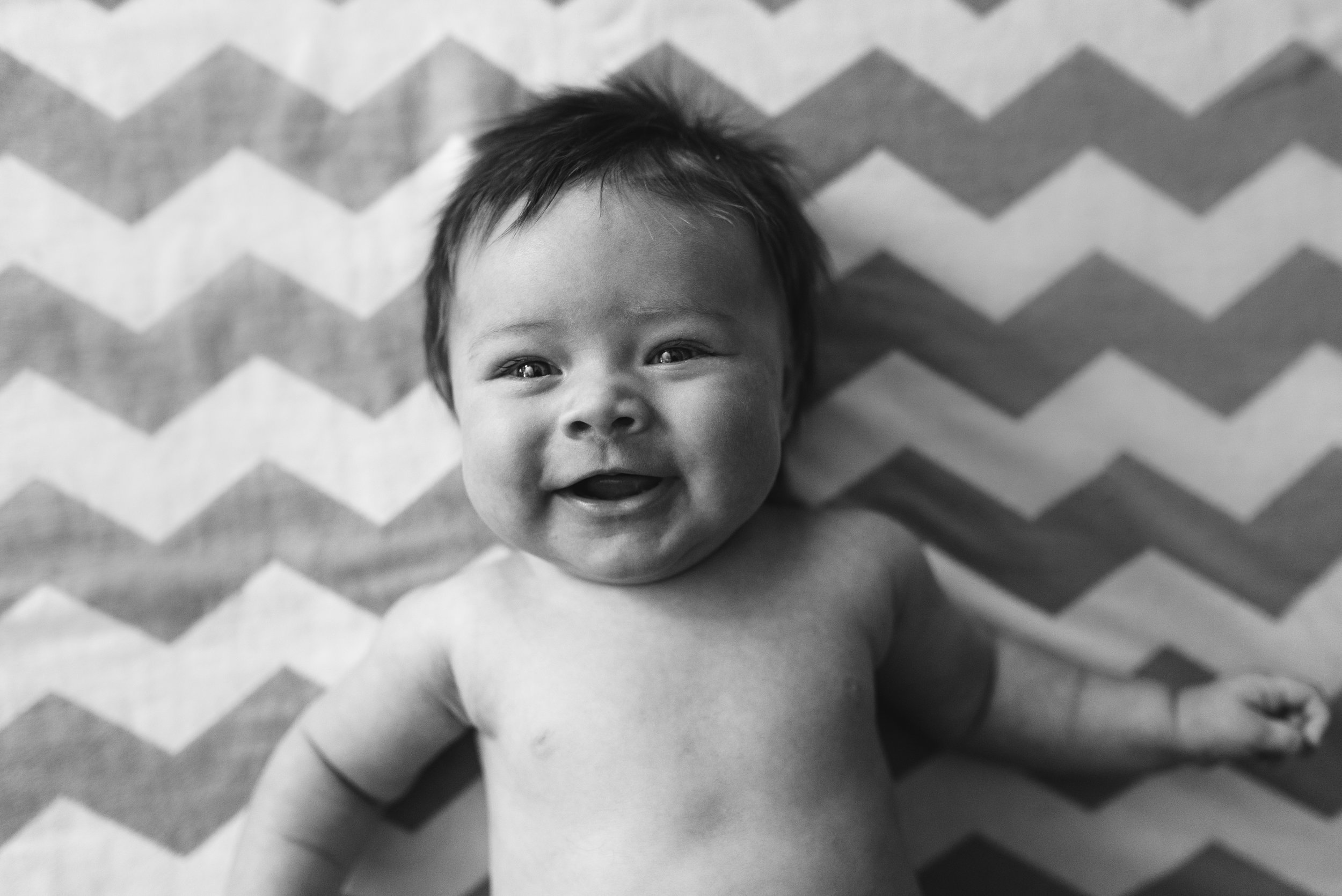 baby smiling on blanket newborn session
