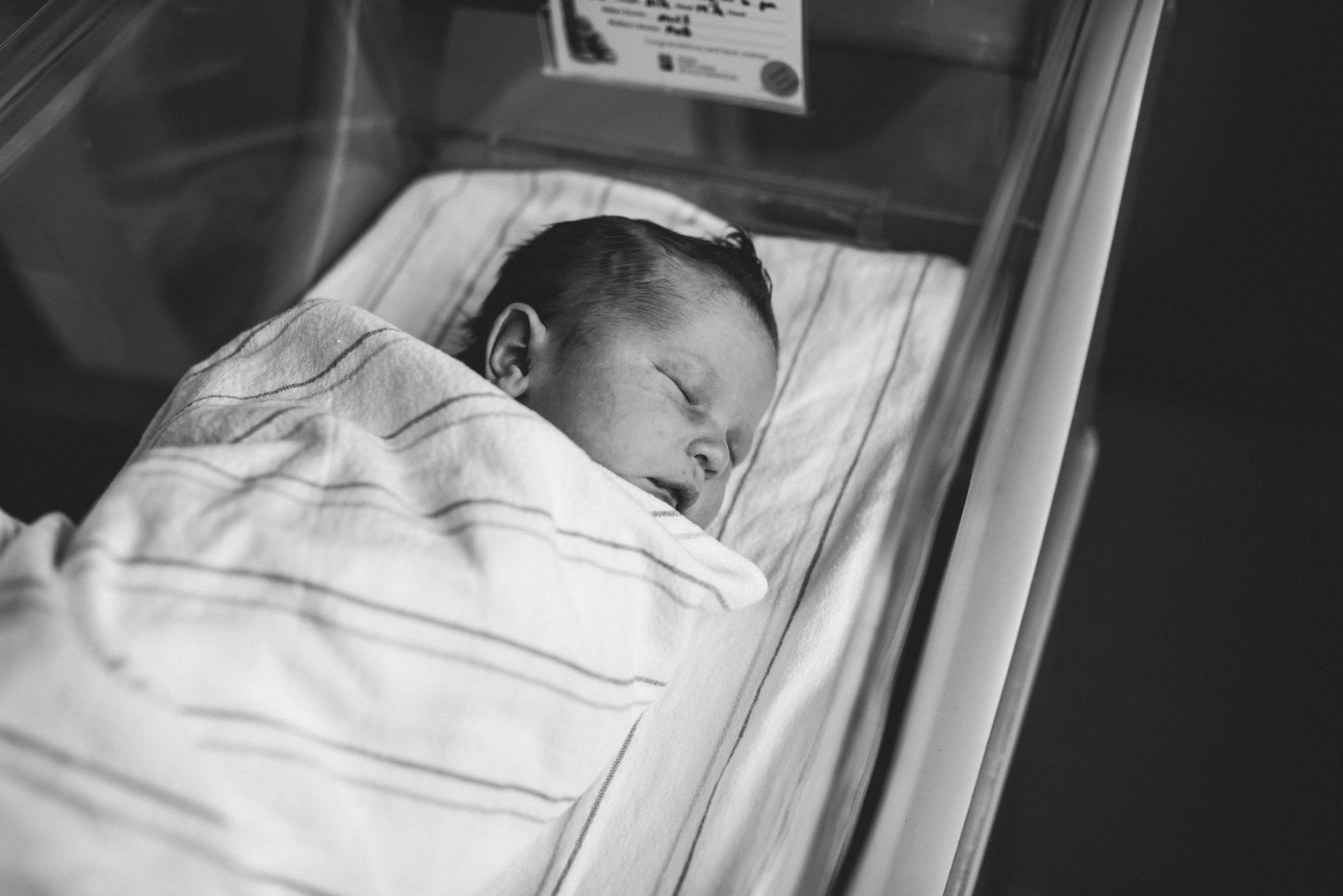 sleeping newborn in hospital bed