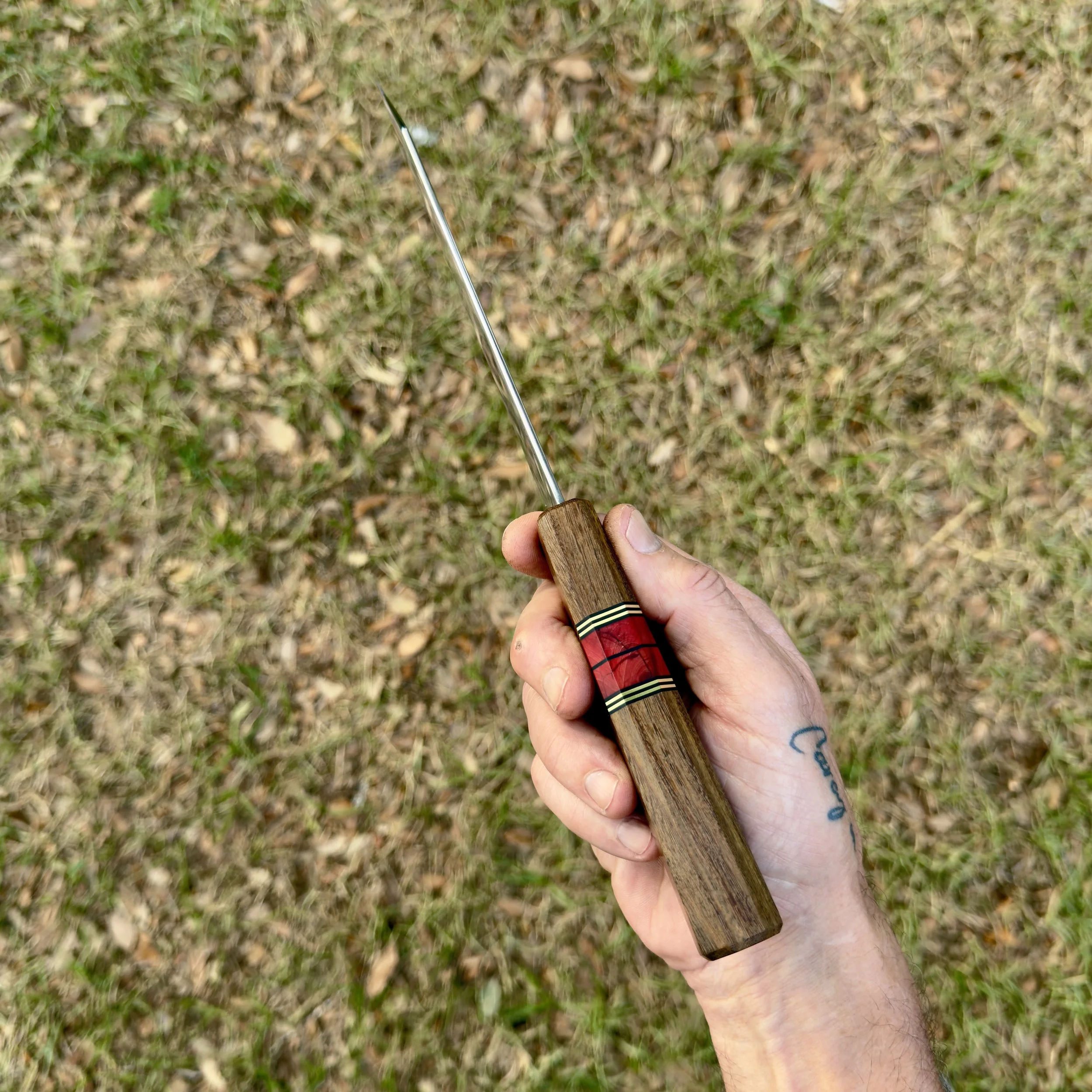 Spine view of chef knife in hand showing thin grind and taper