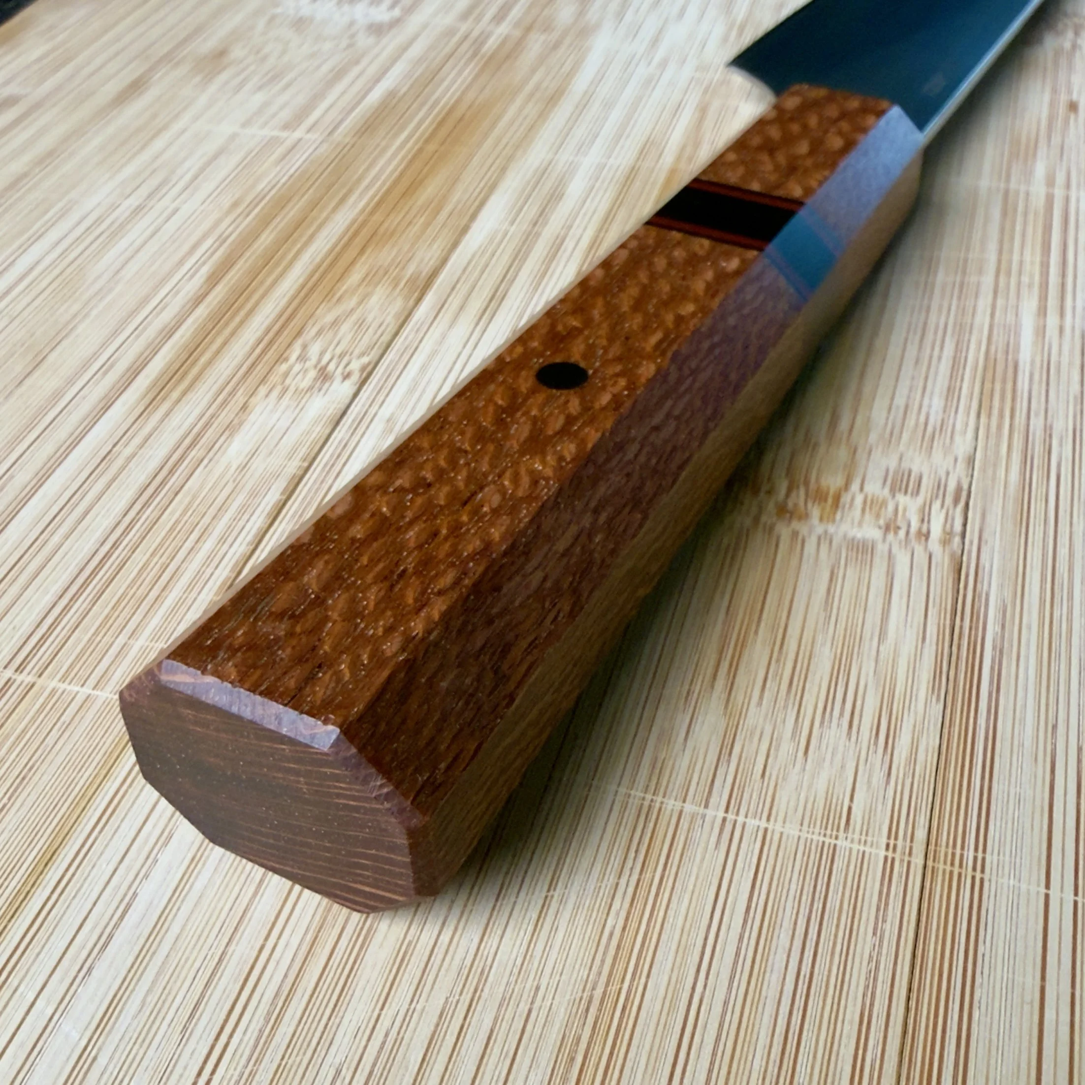 Tapered octagonal lacewood handle detail on handmade 52100 petty kitchen knife
