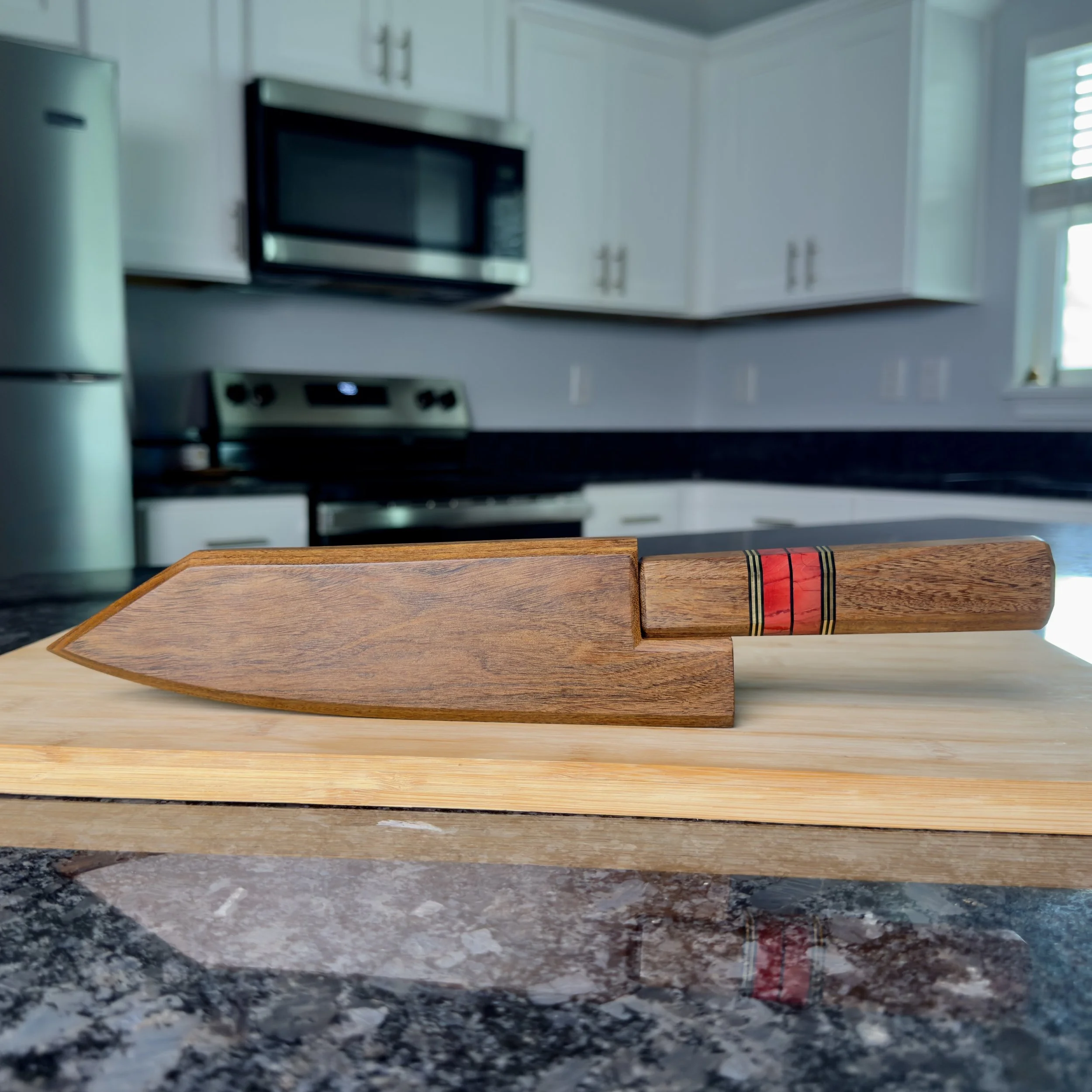Chef knife in lacewood saya on kitchen counter, lifestyle shot