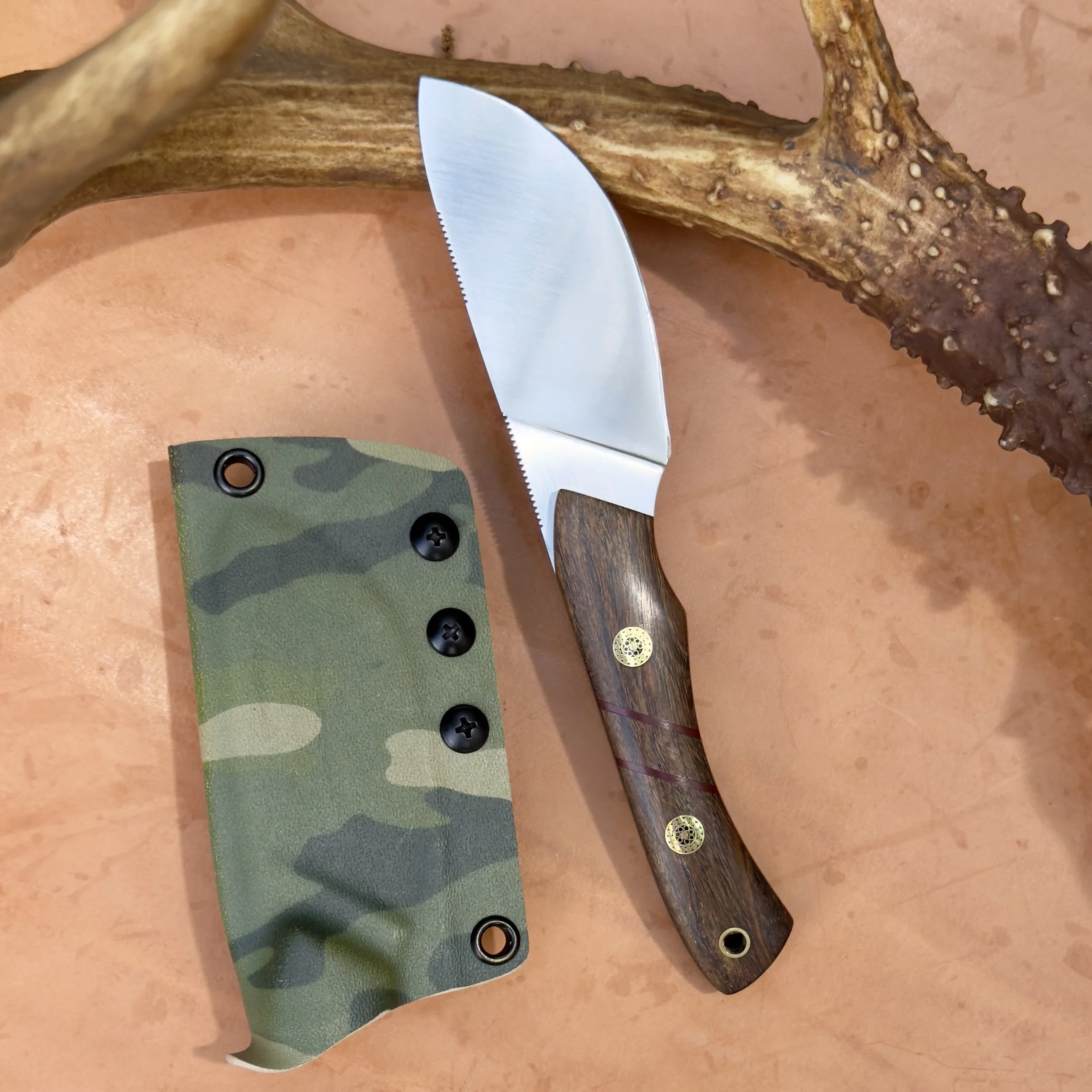 Coffeewood skinner knife with camo Kydex sheath on natural background