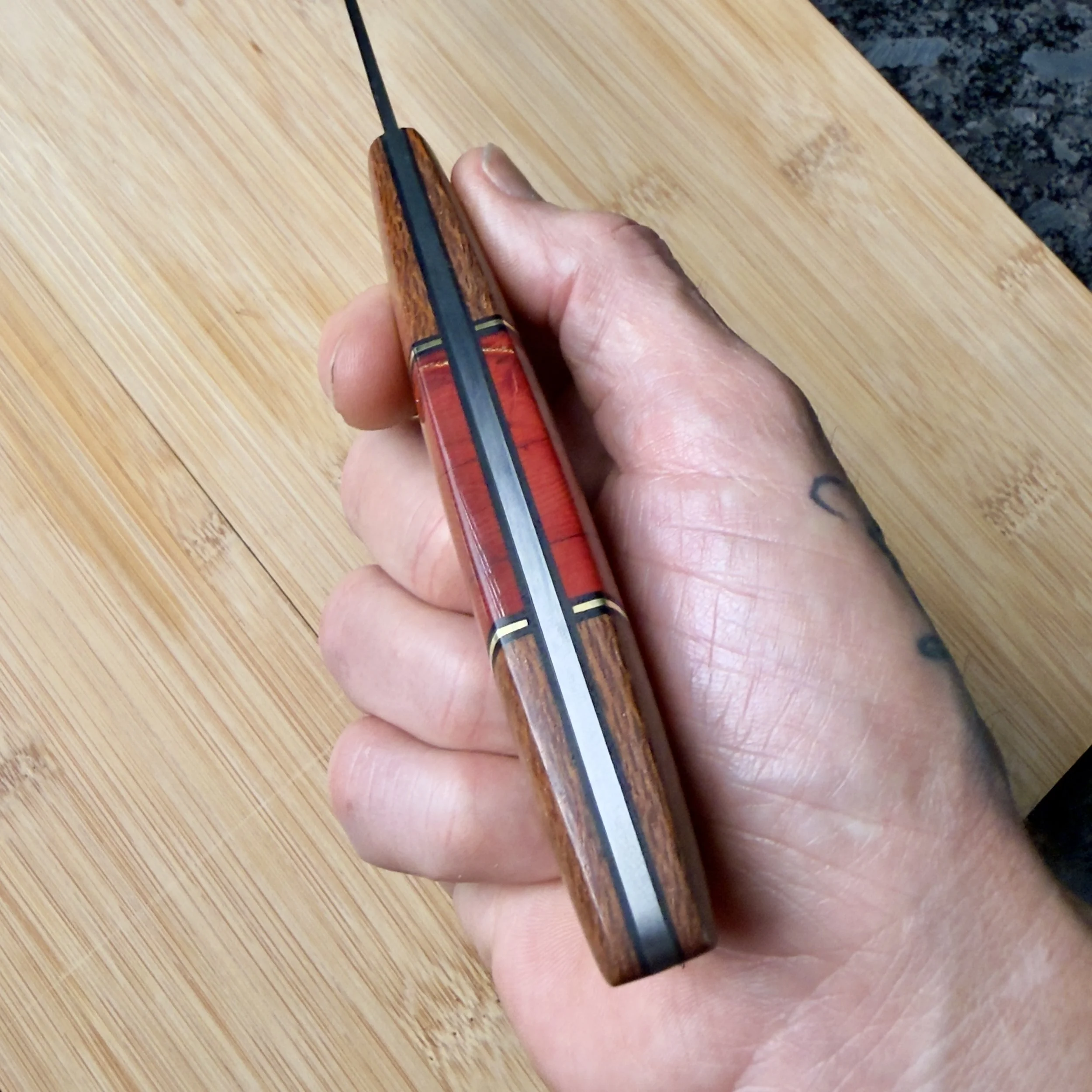 Top view of chef knife handle showing mammoth tusk, brass, and G10 accents