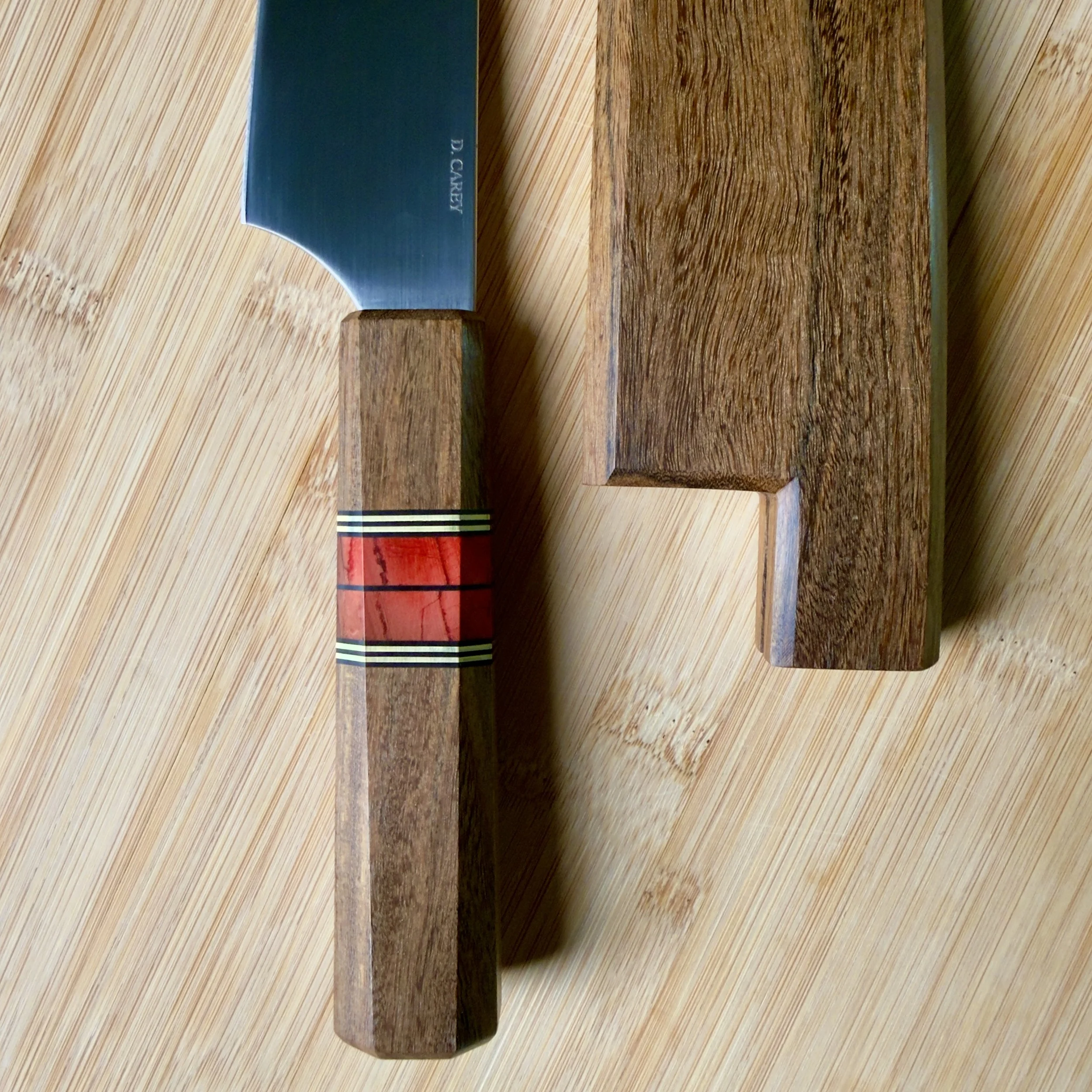 Close-up of Wa handle in coffeewood with red mammoth tusk and brass accents