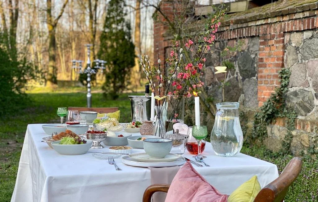 Nasz wielkanocny stół dla dwóch osób ustawiony na świeżym powietrzu w zaciszu pałacowego parku.