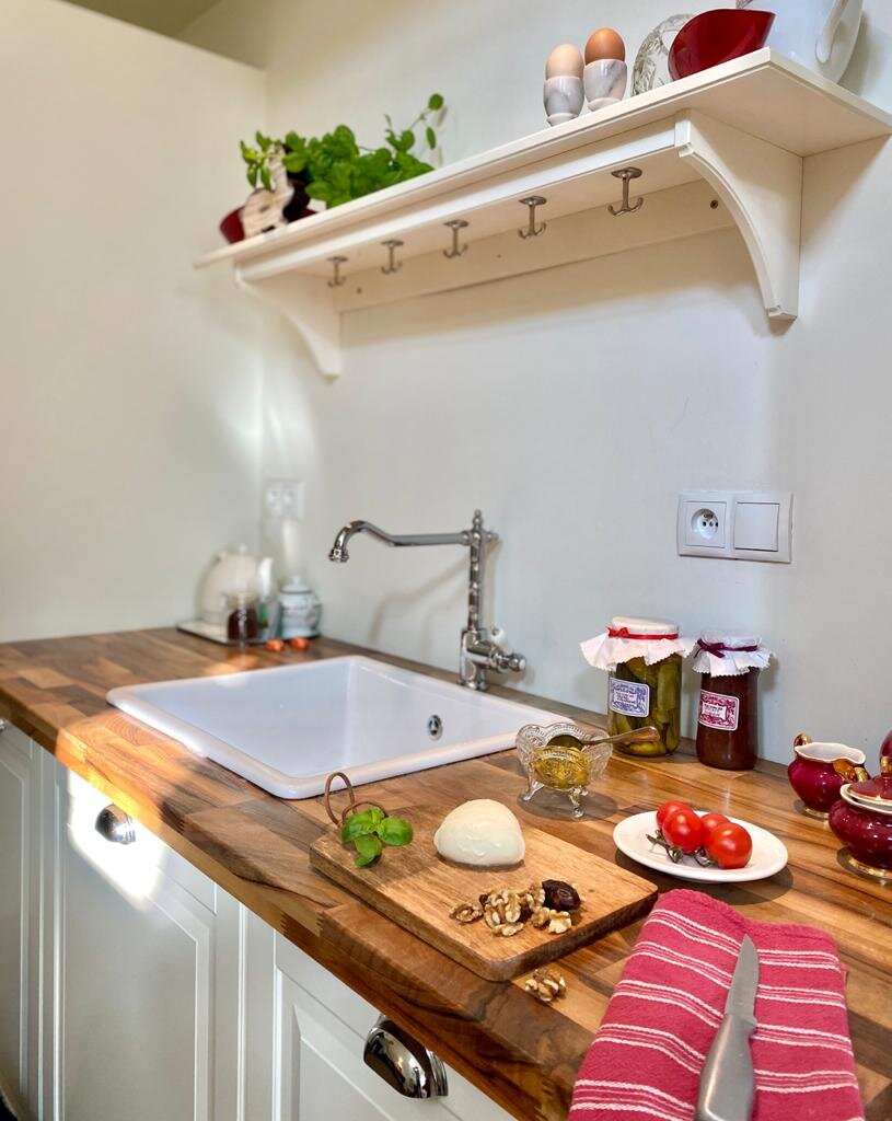 the kitchenette with sink, fridge, and tableware