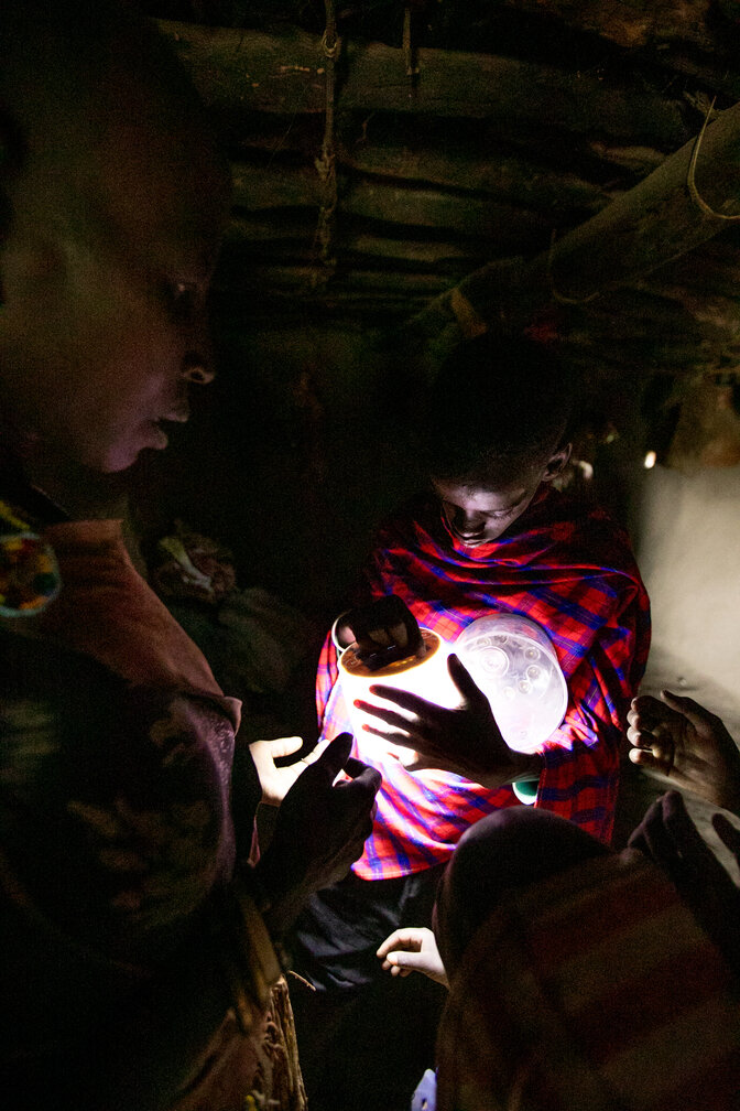 Maasai child holding solar light