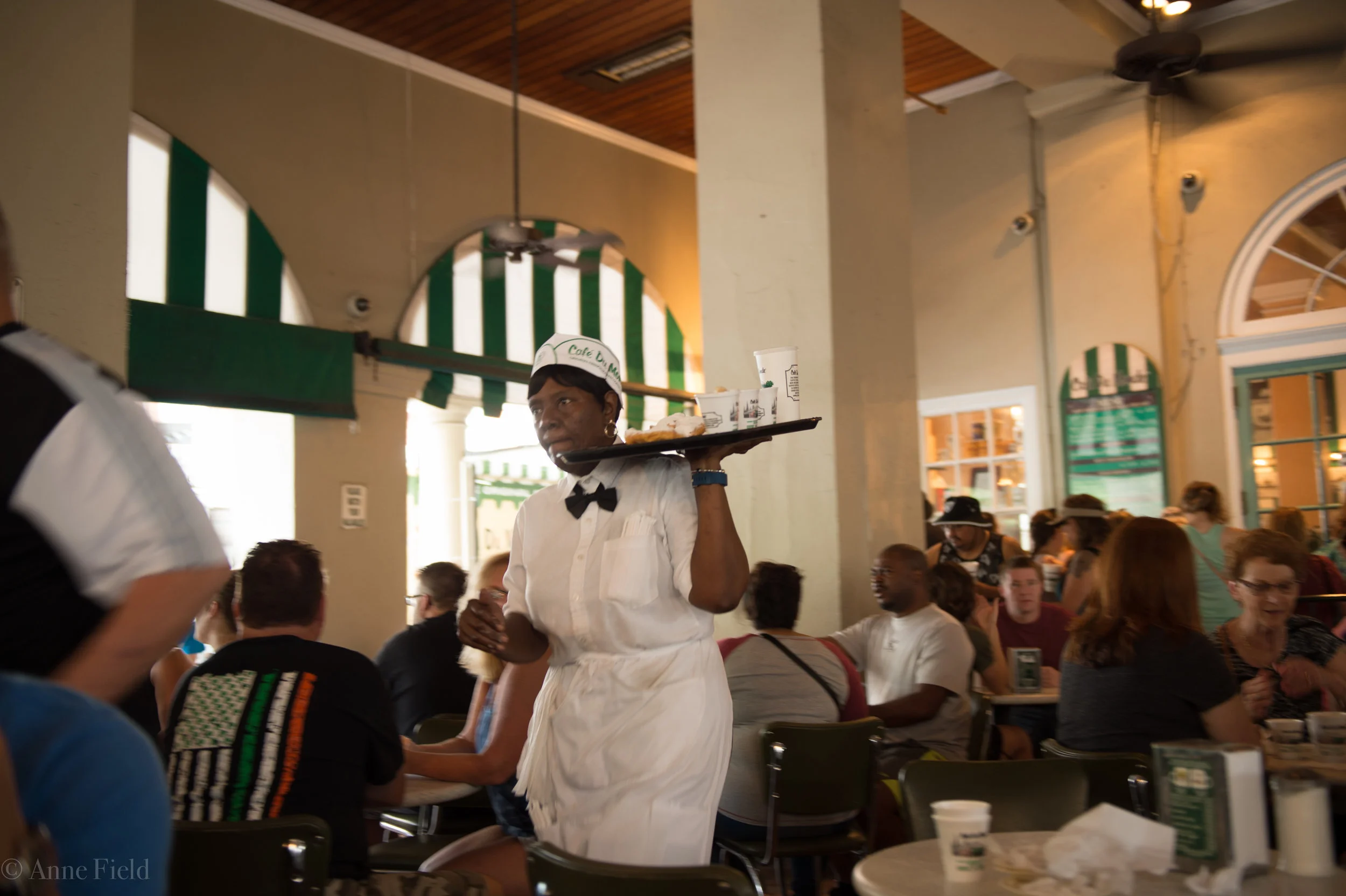 Waitress brings warm beignets, Cafe du Monde, New Orleans. September 2016.