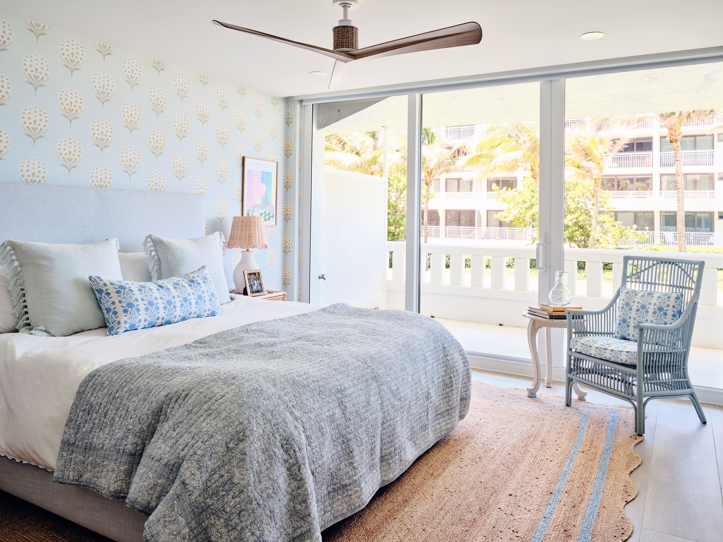 palm-beach-condo-renovation-whitney-ross-bedroom-blue-bed-chair-wallpaper-jute-rug.jpg