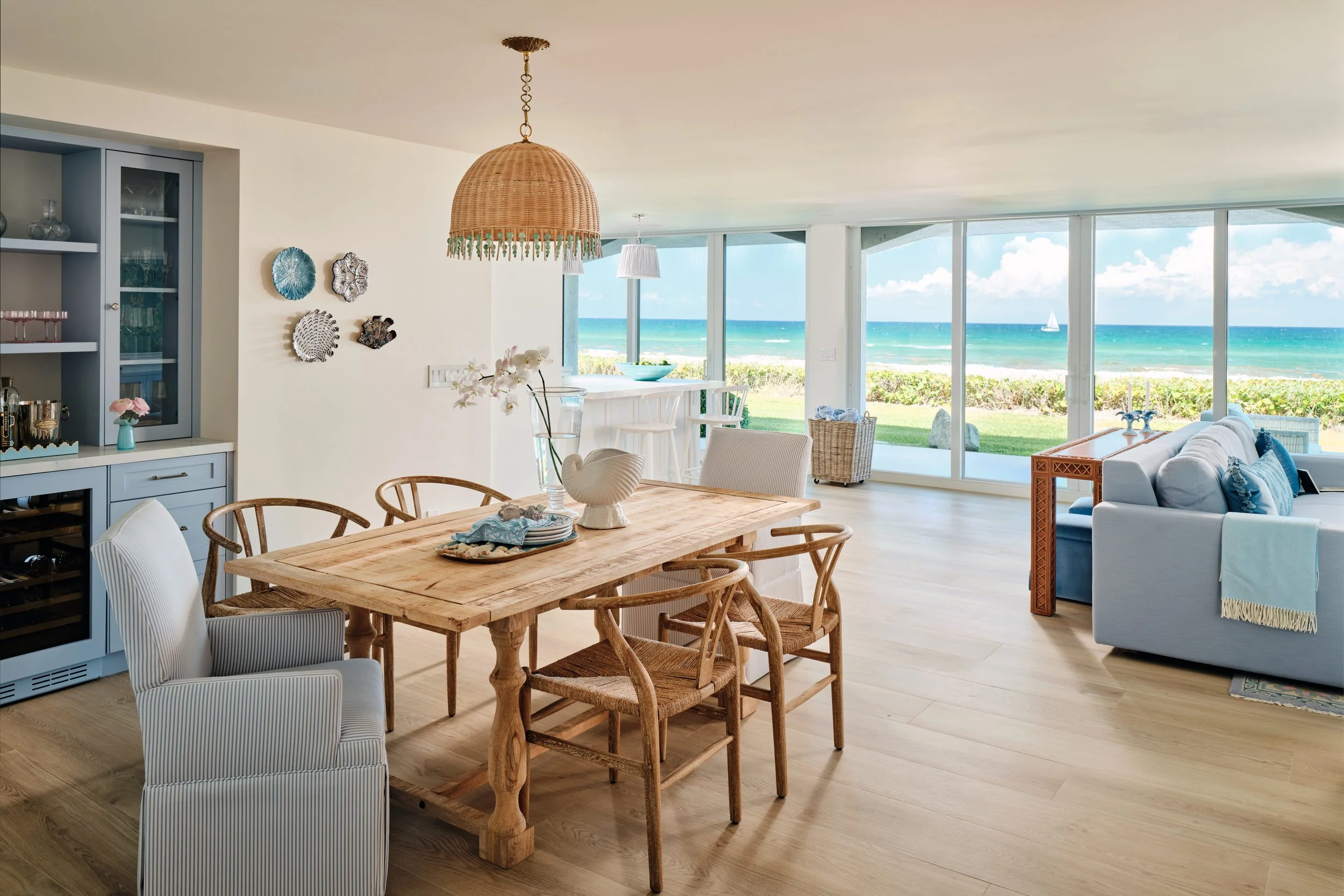 palm-beach-condo-renovation-whitney-ross-dinning-ocean-view-coastal-transitional-wood-table-blue couch.jpg