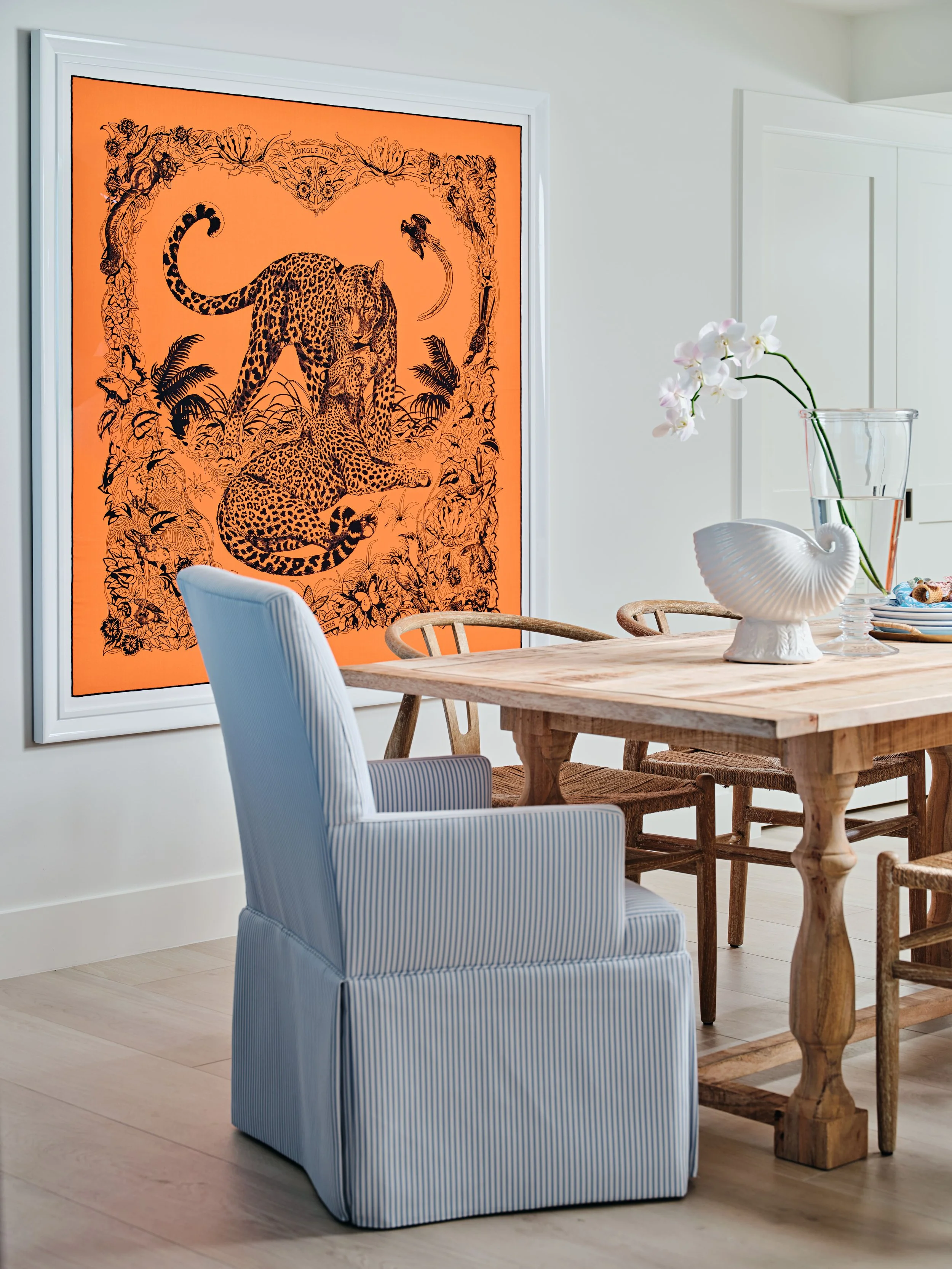 palm-beach-condo-renovation-whitney-ross-dinning-room-blue-armchair-tropical-tiger-art.jpg
