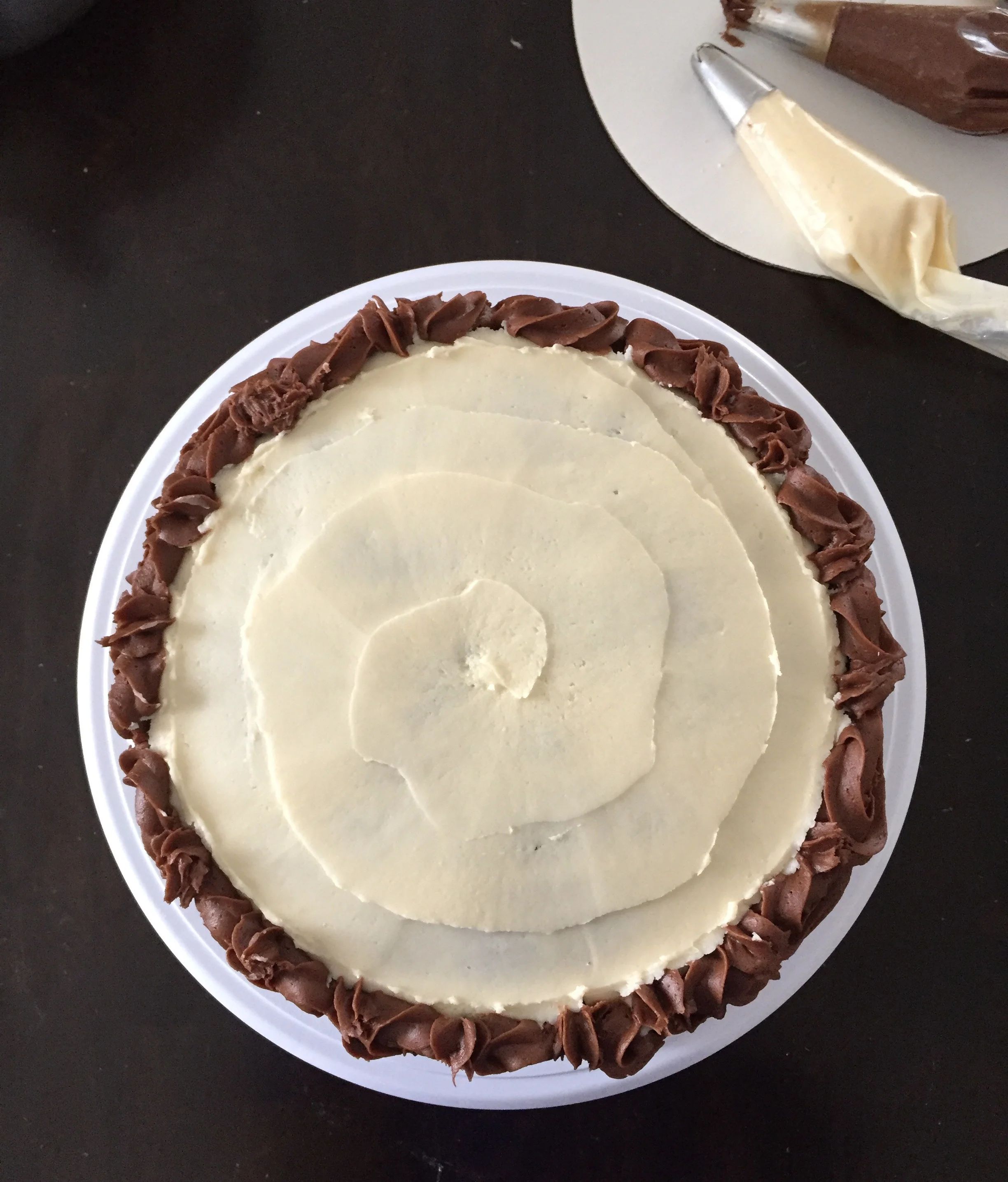 Chocolate Cake w/ vanilla &amp; Chocolate Buttercream  This 9" dual layer round cake is 'the best' chocolate cake. It is surrounded by chocolate buttercream rosettes, but layered and topped with vanilla buttercream. 