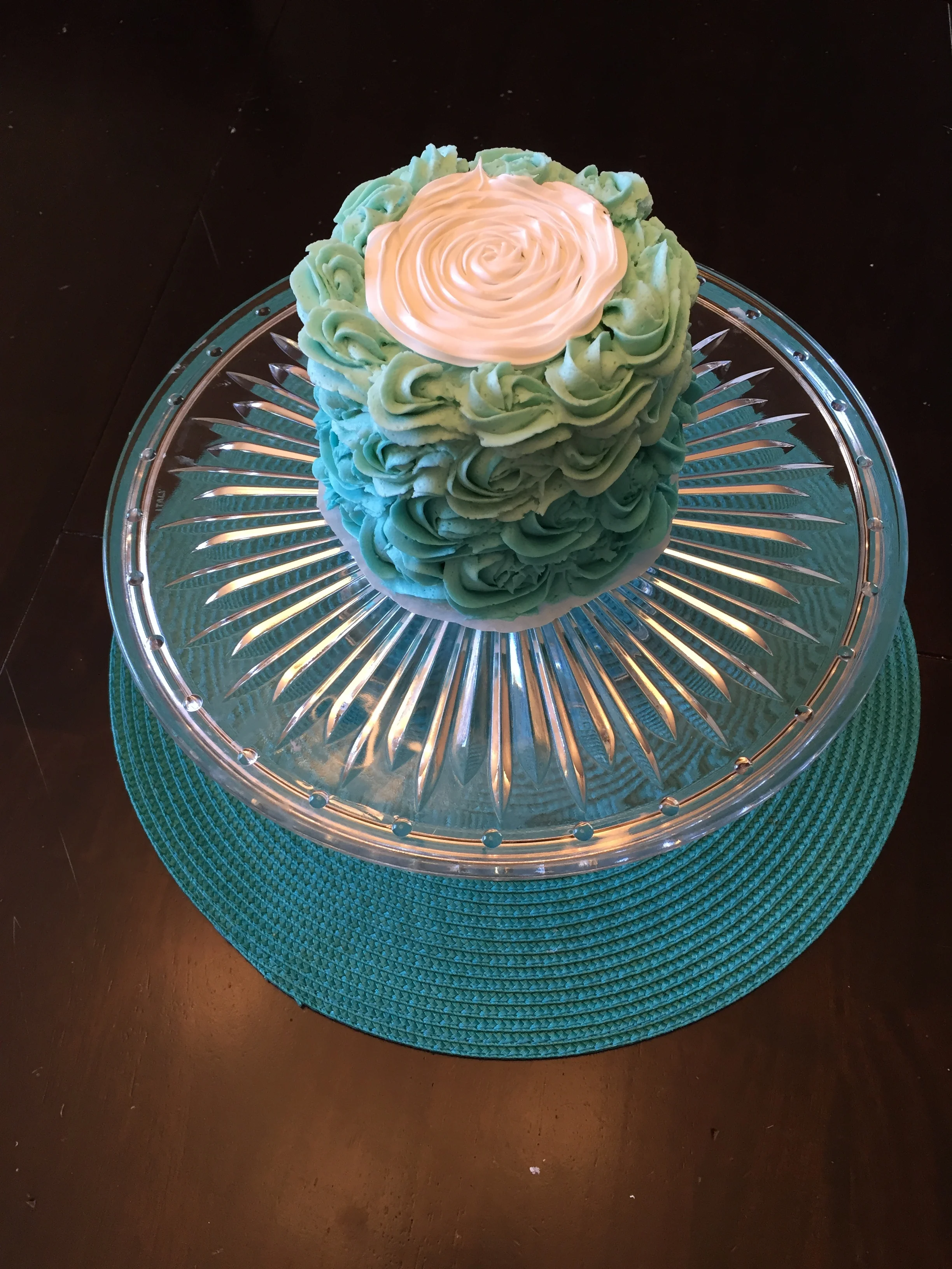   Chocolate cake with Vanilla Ombre Buttercream frosting:   This ombre cake is a three tier cake with the vanilla buttercream as filling and flanking the sides with rosettes.&nbsp; The large white rose in the middle is made with a royal frosting to a