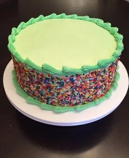 This confetti sided cake is accented with a wave edging.
