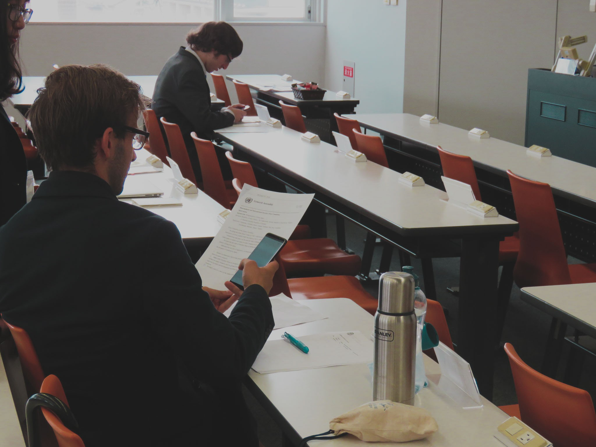  Arriving early at the venue, the delegate of Germany goes over his documents before Day 2 begins. 