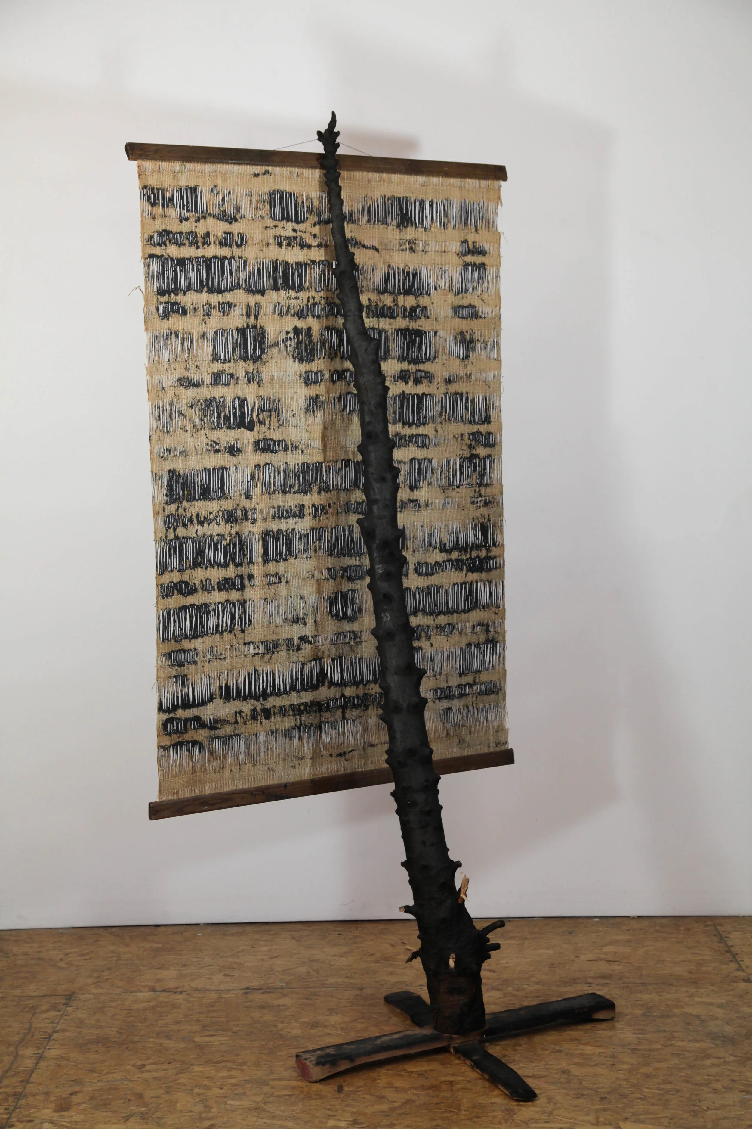 Daniel Gaitor-Lomack The Fruit (Tree), 2017 burned Christmas tree and tapestry 81 x 38 x 30 in.