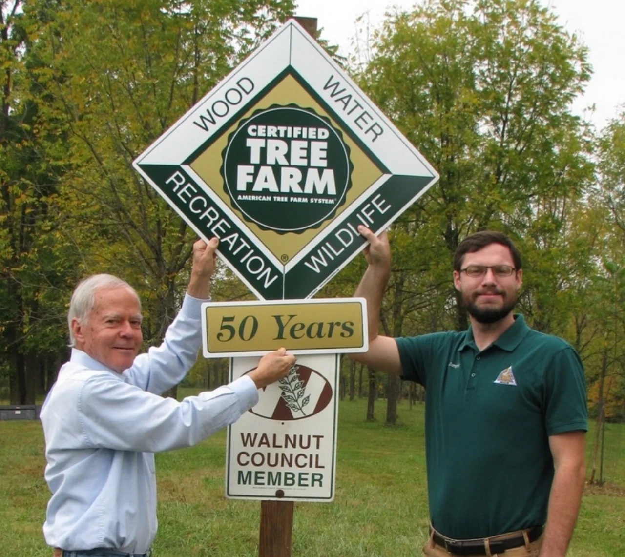 Mike Trial receiving 50-year tree farm sign.